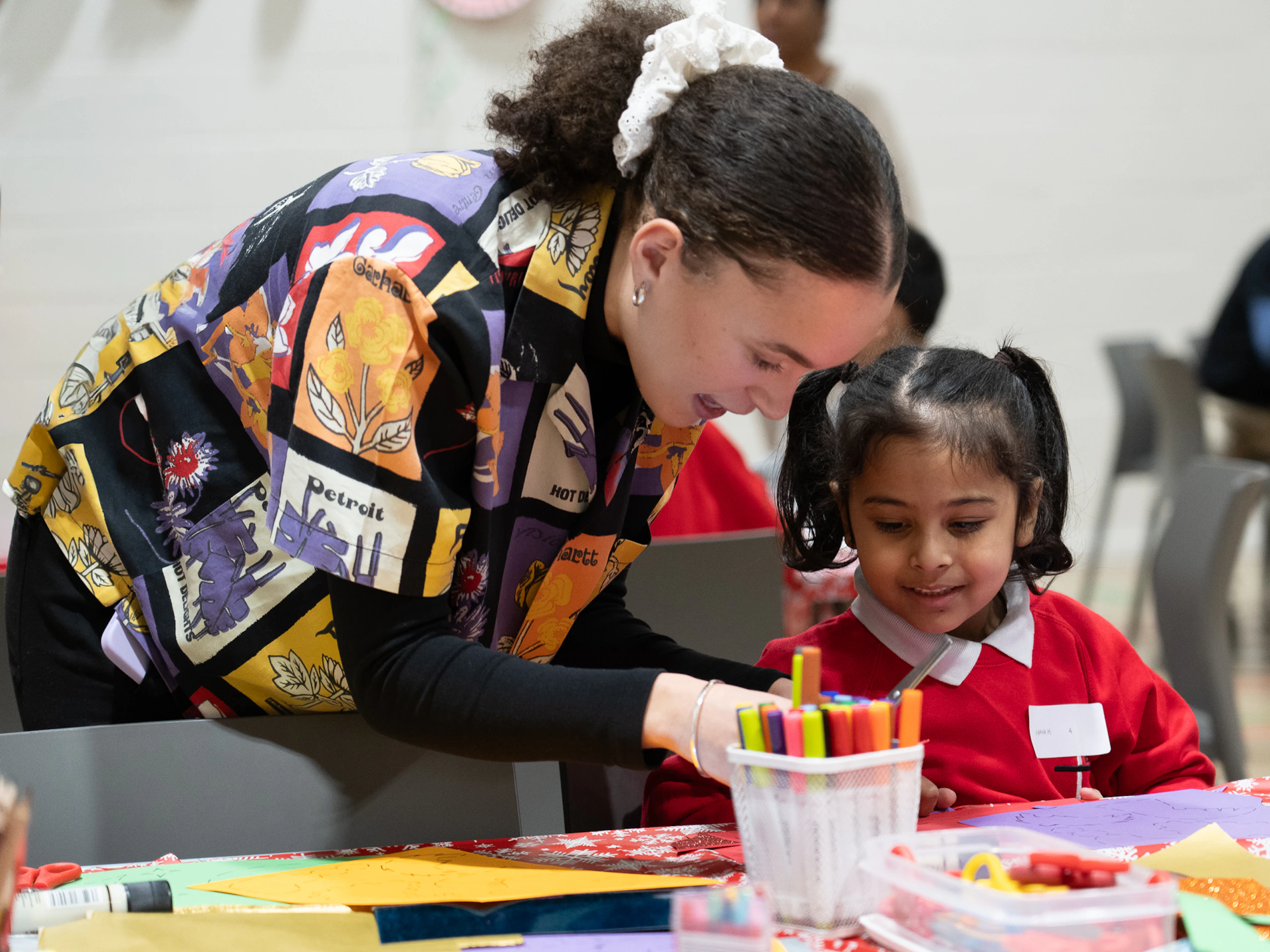Young girl crafting at a MillerKnoll We Care event with illustrator Beth Suzanna from the Quentin Blake Centre for Illustration, a local MillerKnoll charity partner in London.
