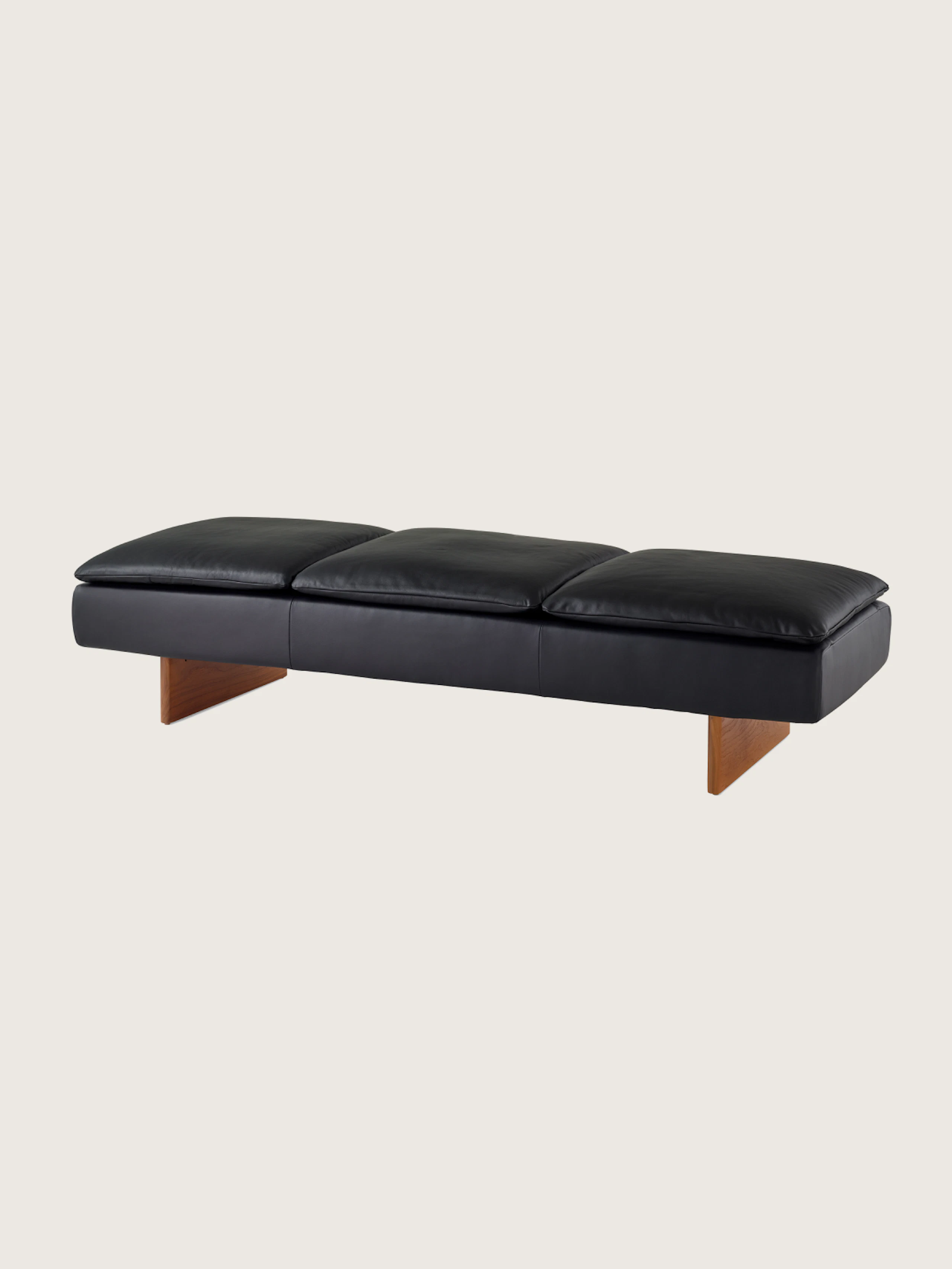 Mantle Three Seater Bench in black leather with a walnut base, viewed at an angle.