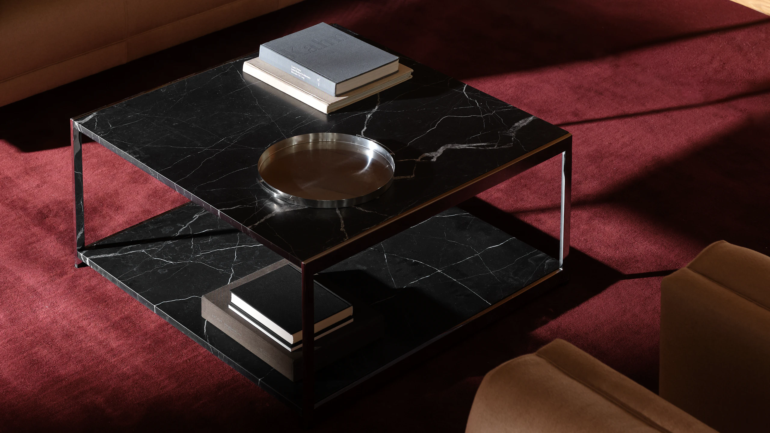 H Frame Coffee Table with a Nero Marquina Marble top and bottom and chrome frame, positioned between a Rolled Arm Sofa and two Rolled Arm Club Chairs, viewed from above at an angle on a burgundy rug.