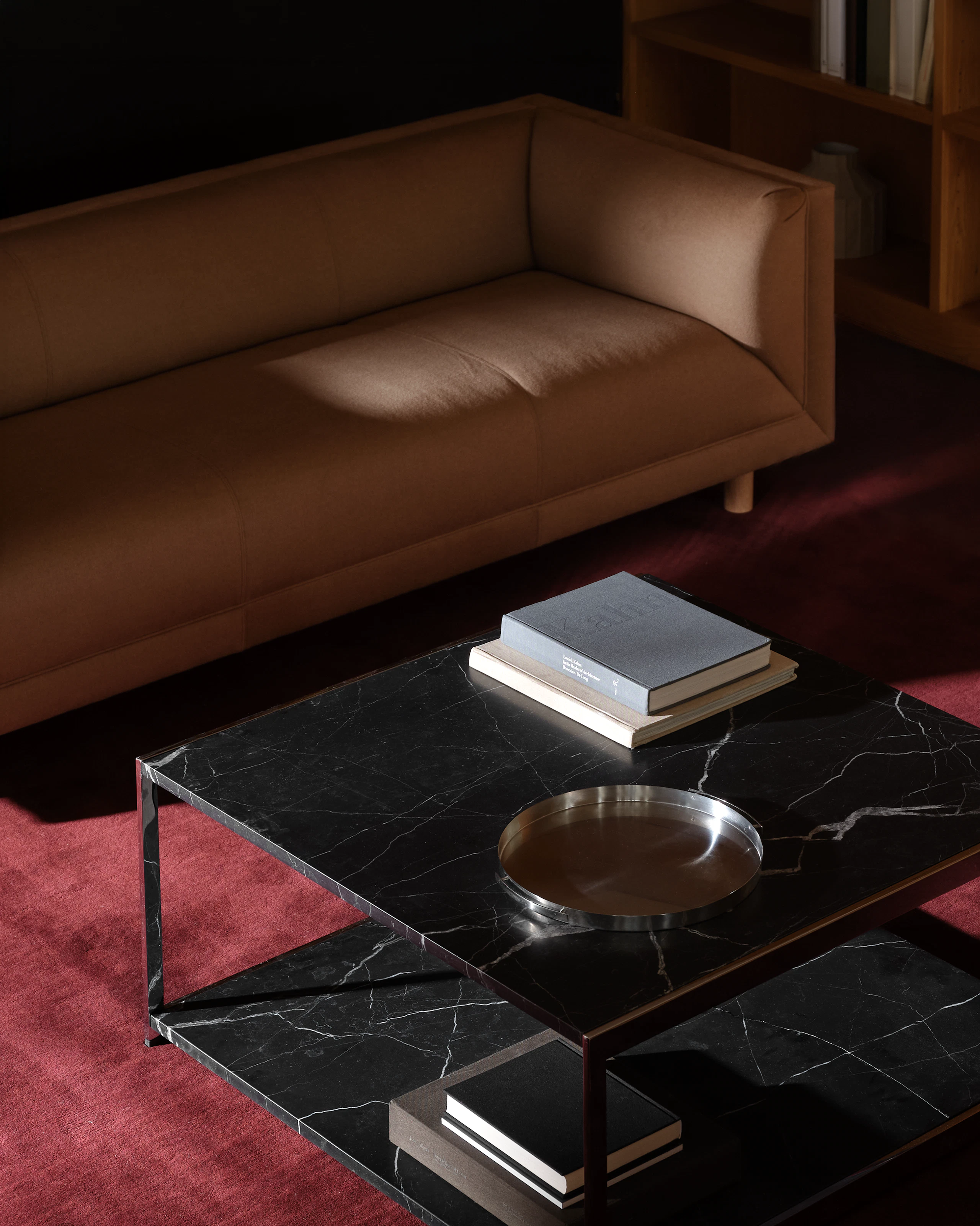 H Frame Coffee Table with a Nero Marquina Marble top and bottom and chrome frame, positioned between a Rolled Arm Sofa and two Rolled Arm Club Chairs, viewed from above at an angle on a burgundy rug.