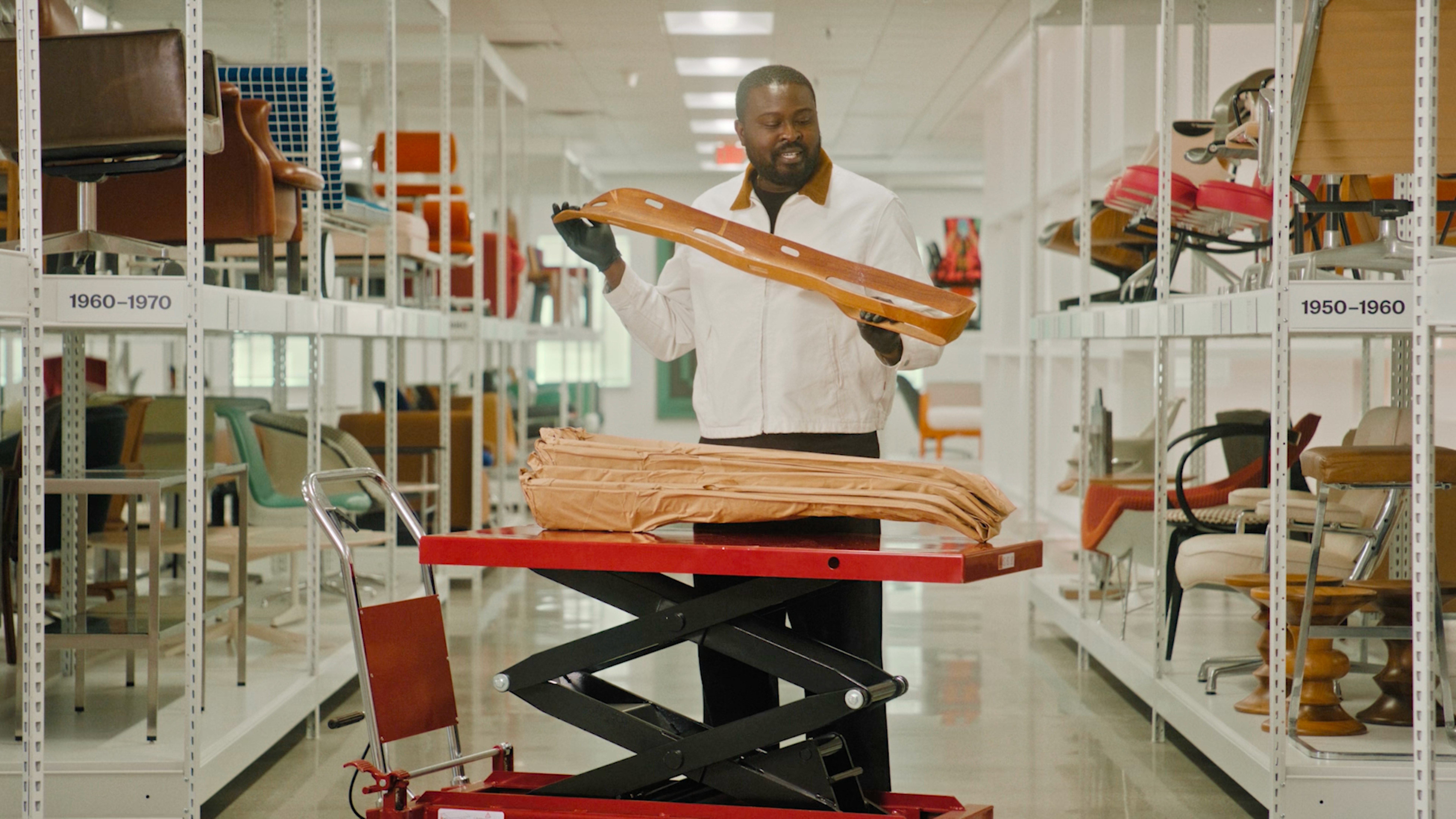 Nifemi Marcus-Bello inspecting a splint designed by Charles and Ray Eames at the MillerKnoll Archives.