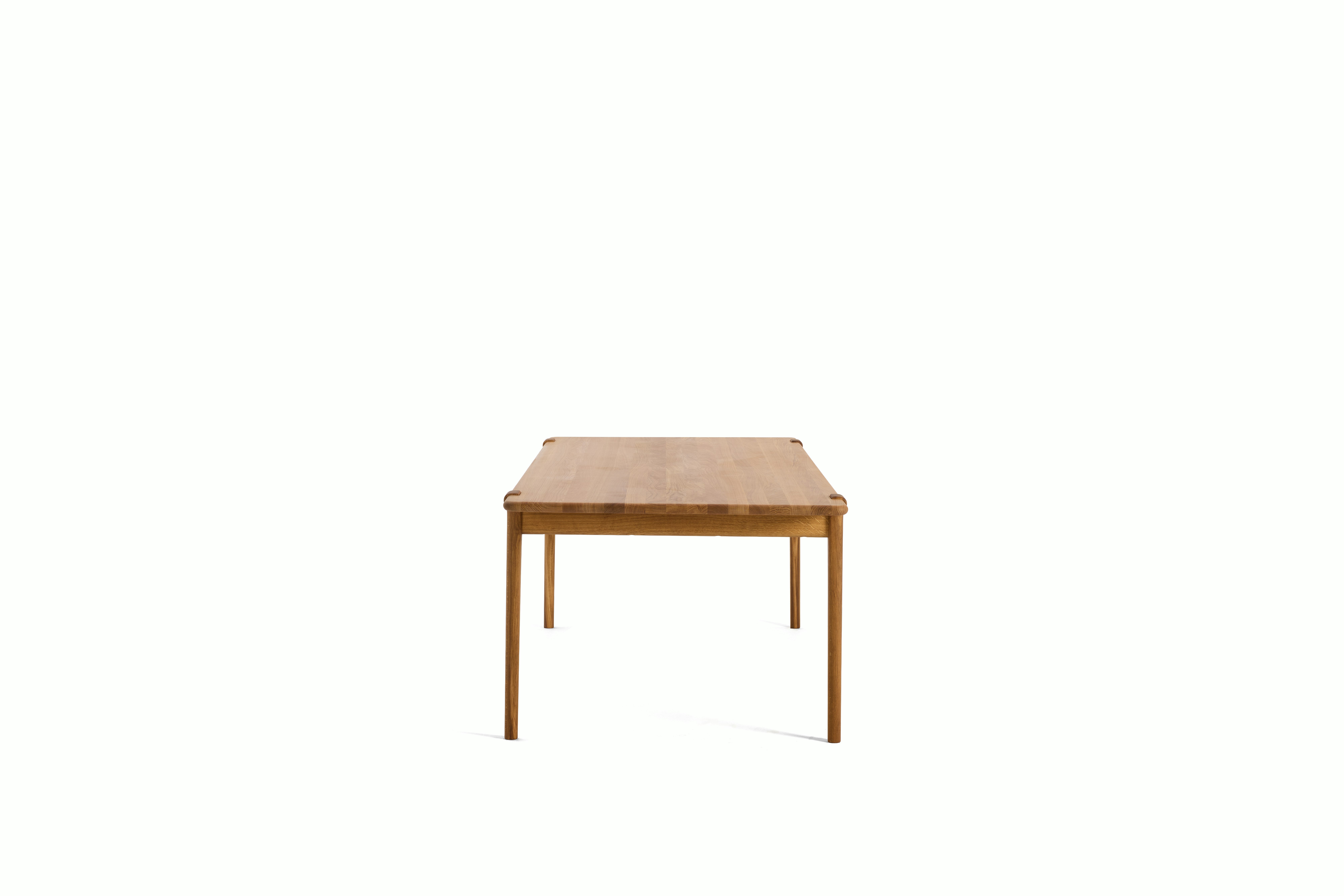 An Otto Dining Table in Oak viewed from the side.