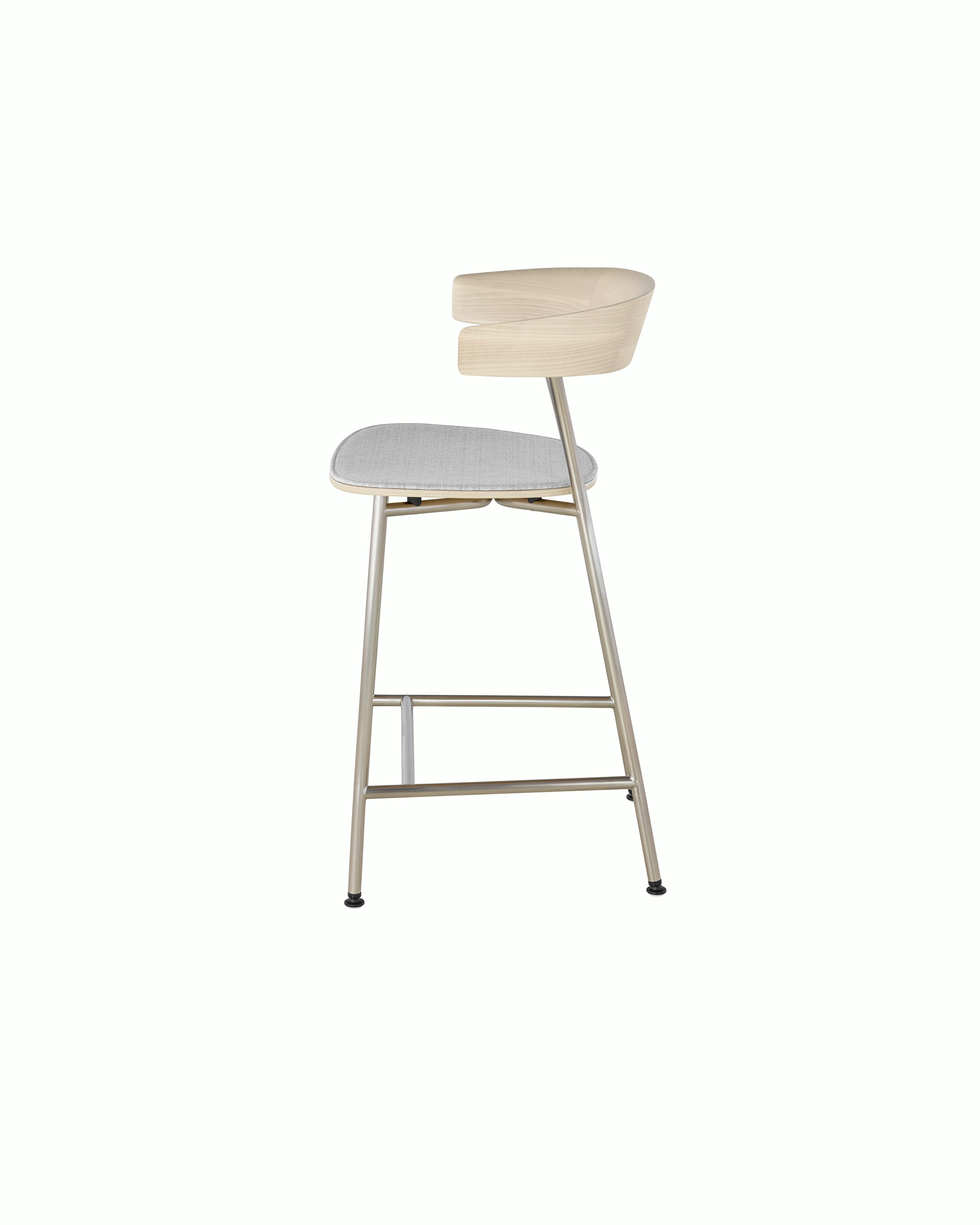 Side view of a Leeway Stool, showing the crescent-shaped, cantilevered backrest with a light wood finish.