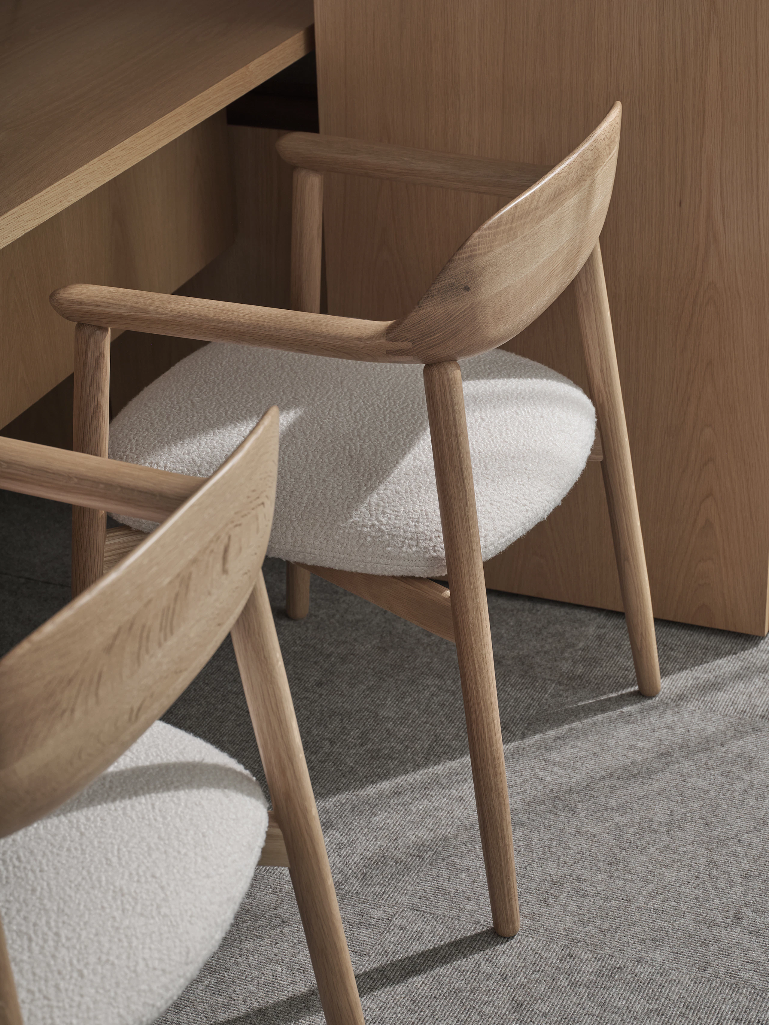 Two Crosshatch Armchairs in Natural Oak upholstered with Maharam Firth in Limewash, viewed from above at an angle in a Geiger One Private Office.