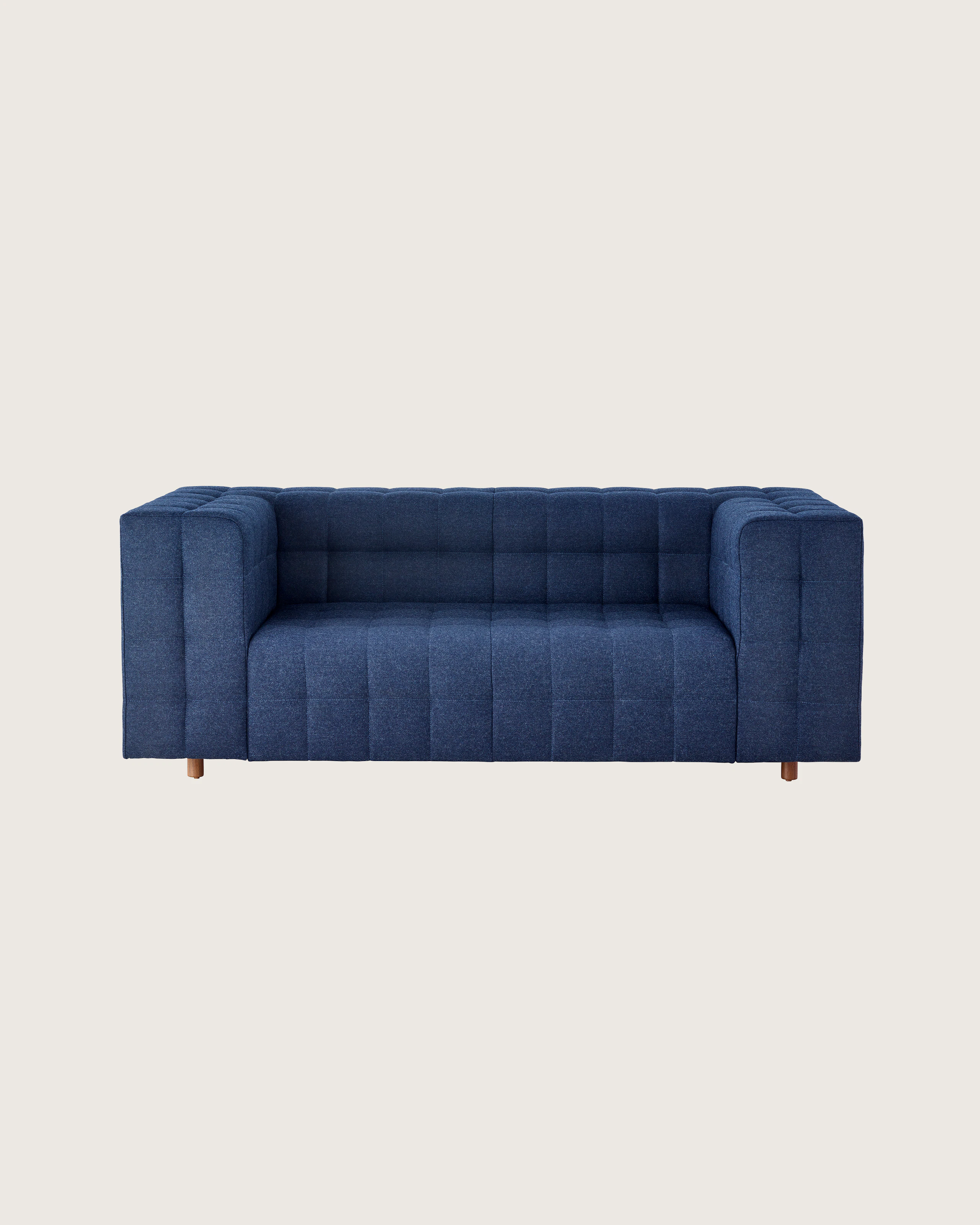 A two-seat Rapport Sofa in a deep navy colored textile, viewed at an angle.