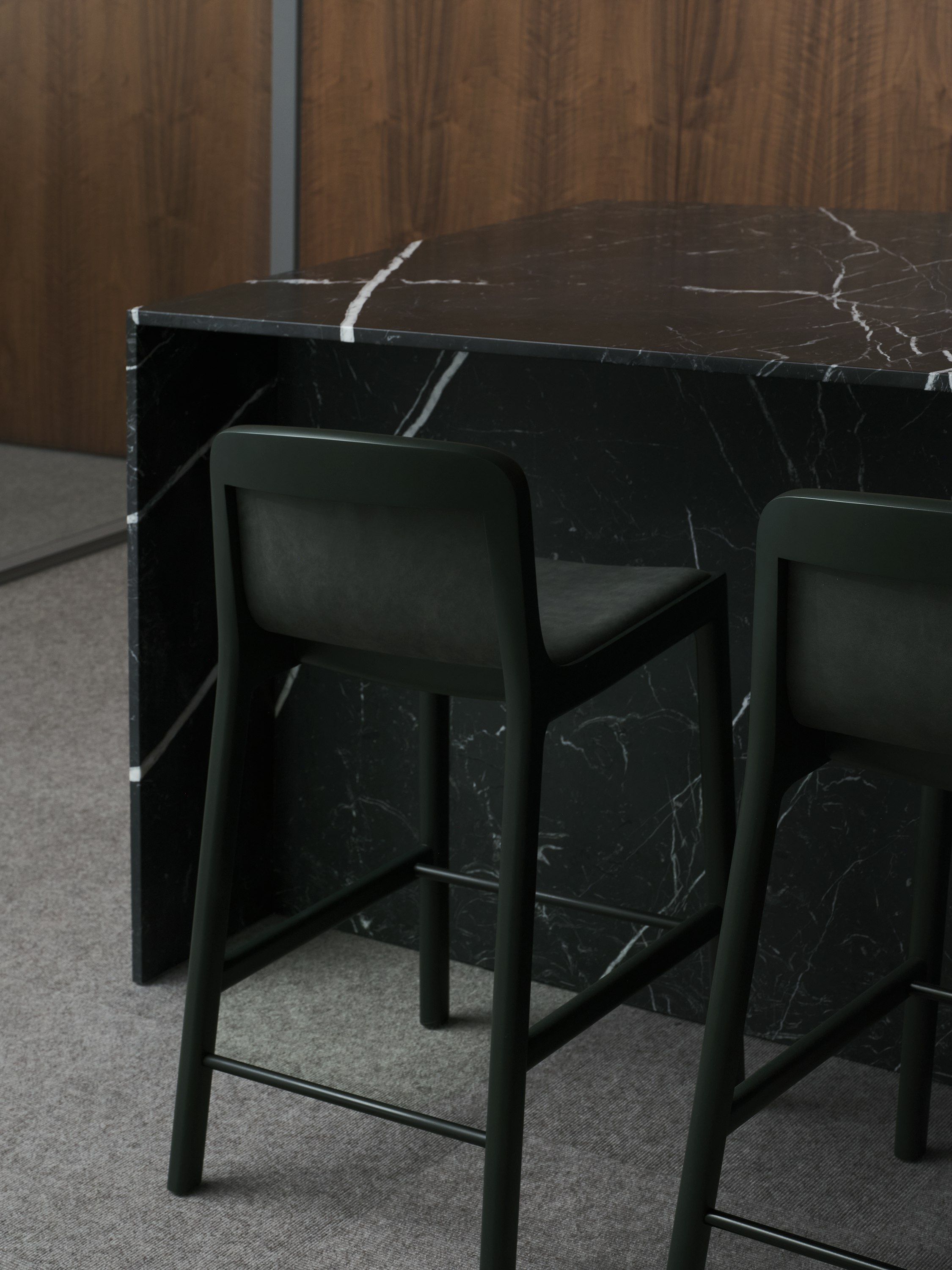 Two counter height Lijn Stools in Ivy upholstered with Edelman Fount in Bracke with a custom Geiger reception desk in Nero Marquina marble, viewed from behind at an angle.