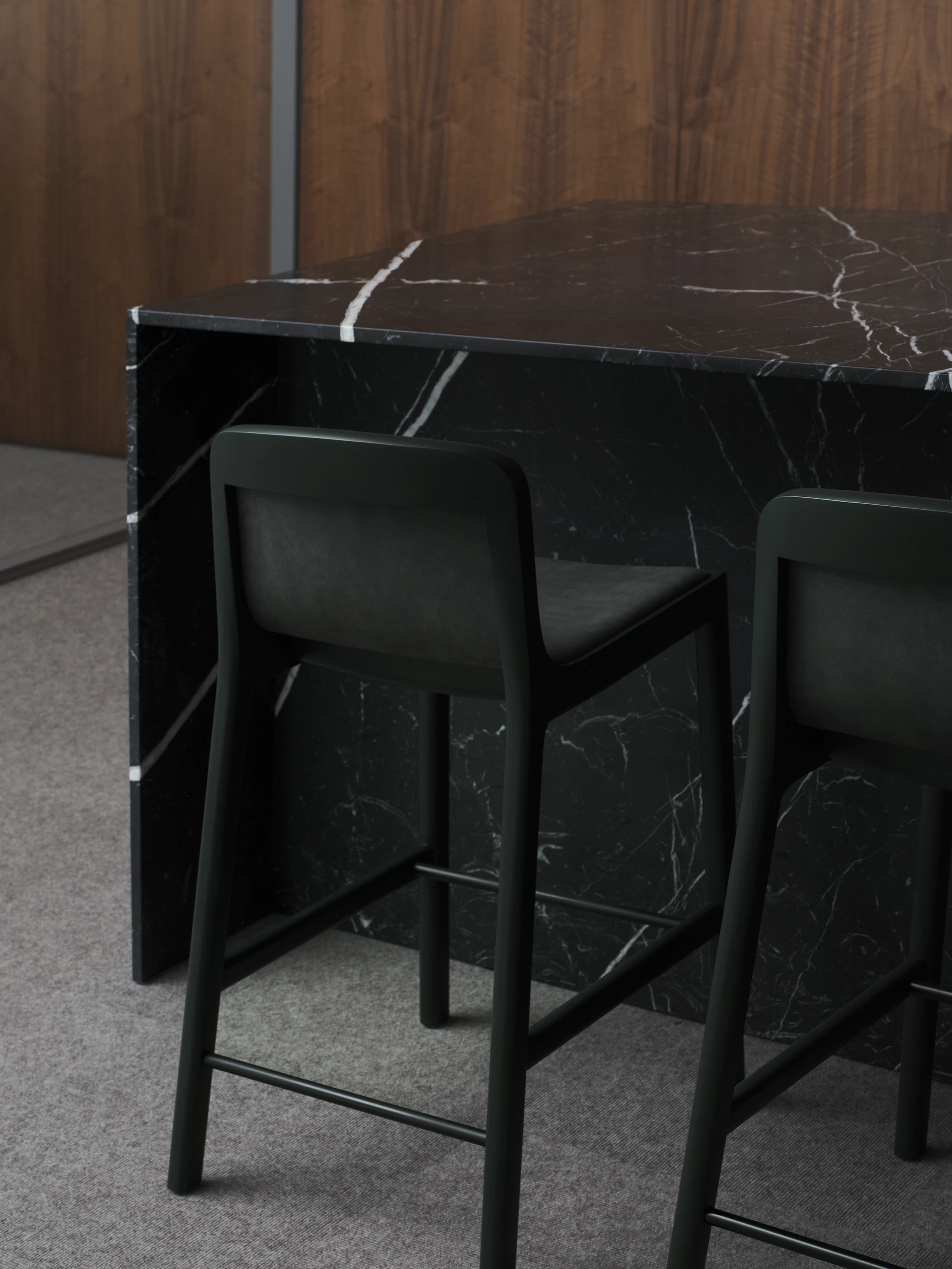 Two counter height Lijn Stools in Ivy upholstered with Edelman Fount in Bracke with a custom Geiger reception desk in Nero Marquina marble, viewed from behind at an angle.