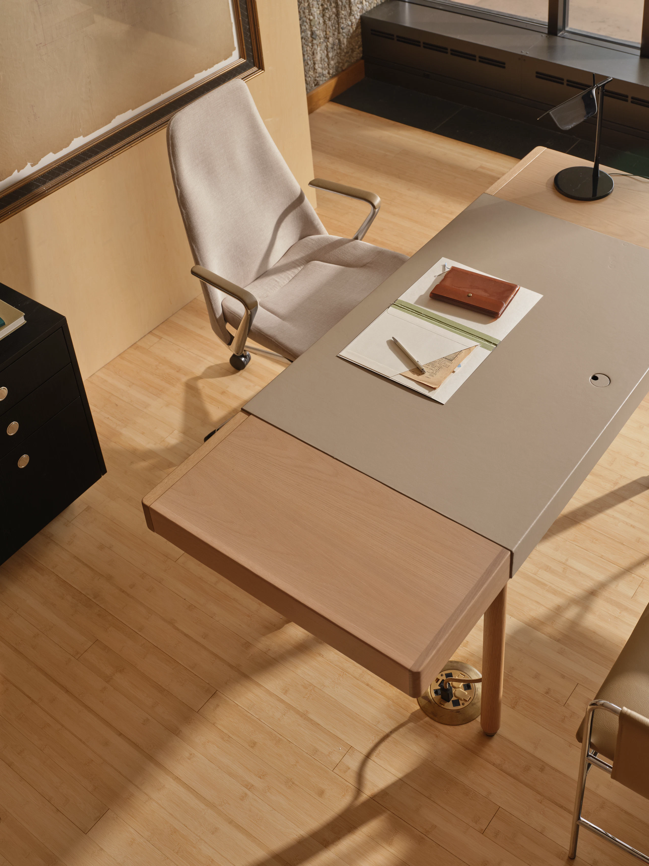 New Canaan Leatherwrap Desk, Tape Chair, two Envelope Chairs for guests, and a Sled Base Storage Pedestal, viewed from above at an angle in an office setting.