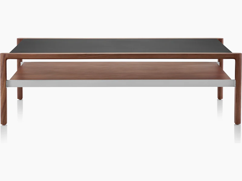 Partial front view of a rectangular Brabo coffee table with a black Bristol Leather-wrapped top, walnut lower shelf, and metal frame supports.