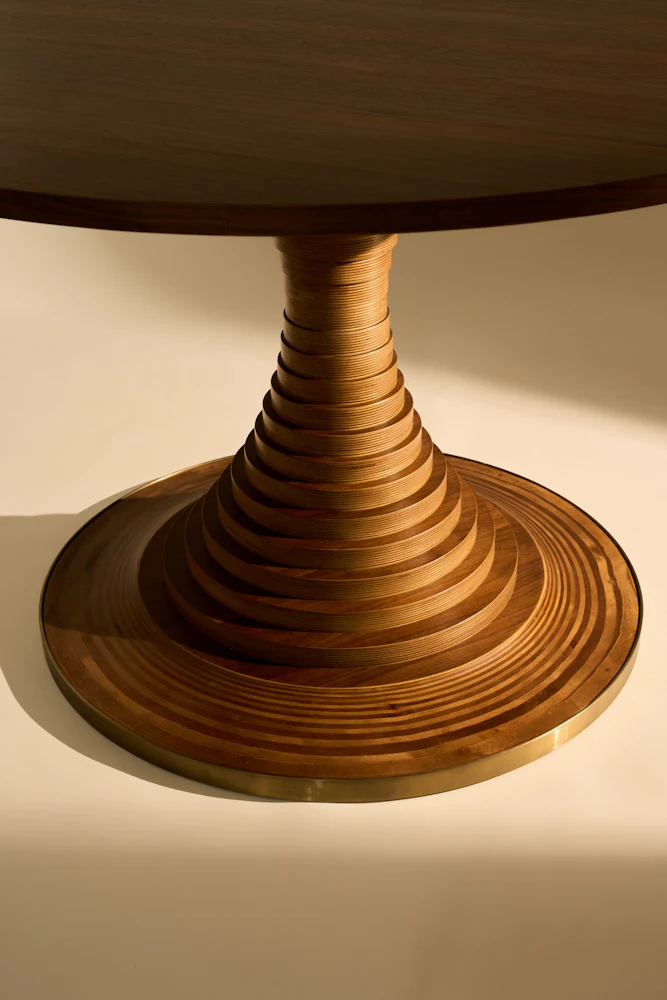 Close up interior view of wooden table edge showing curved concentric rings on the surface