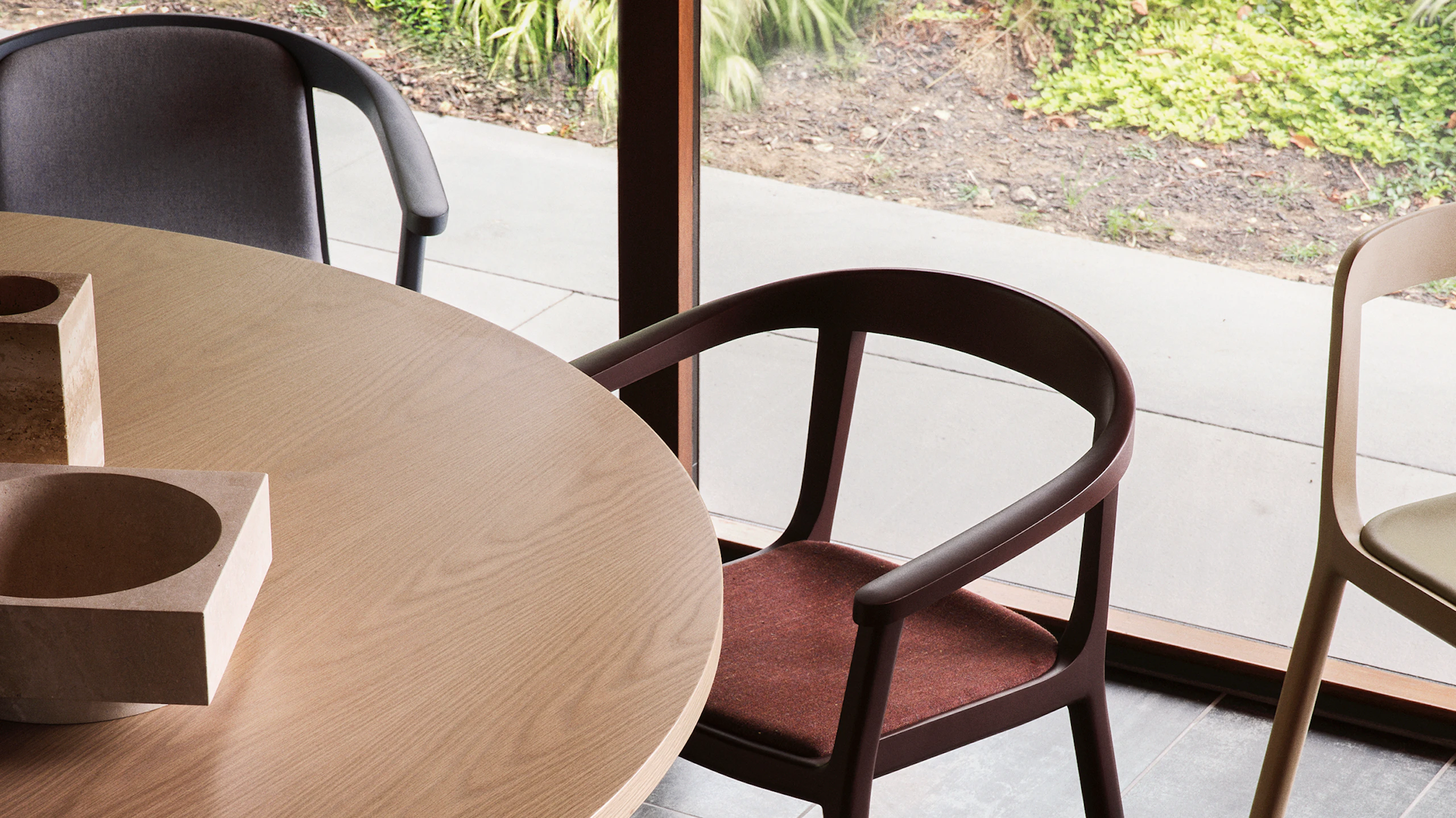 Lijn Armchairs and Side Chairs designed by Carole Baijings for Geiger in a variety of wood stains, textiles, and leather upholsteries shown surrounding a JD Meeting Table.