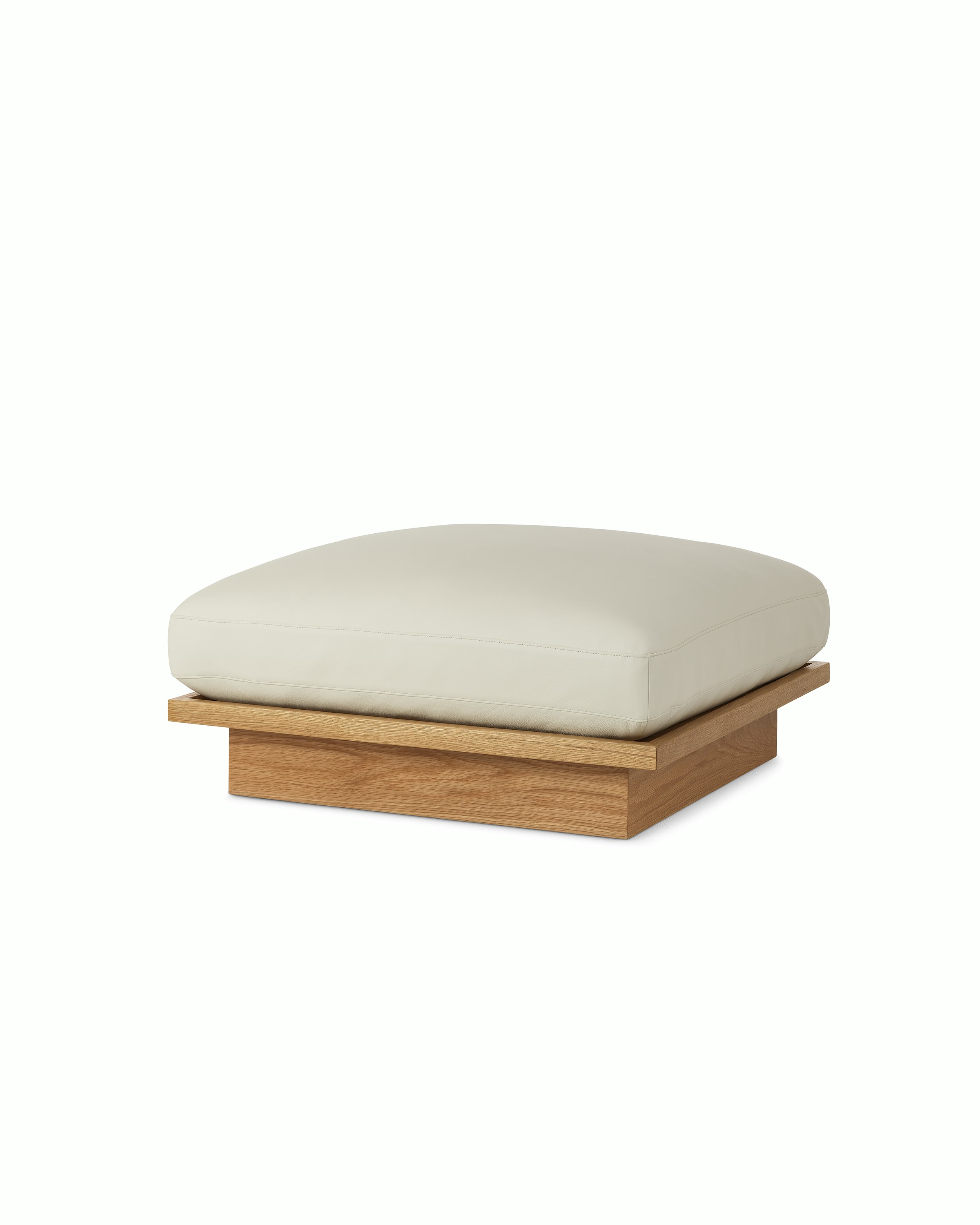 Pawson Drift Ottoman with white leather upholstery and white oak base, viewed from an angle.