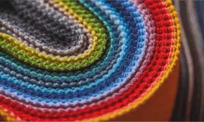 A bright range of colorful fabrics stacked on top of each other and folded into a U-shape.