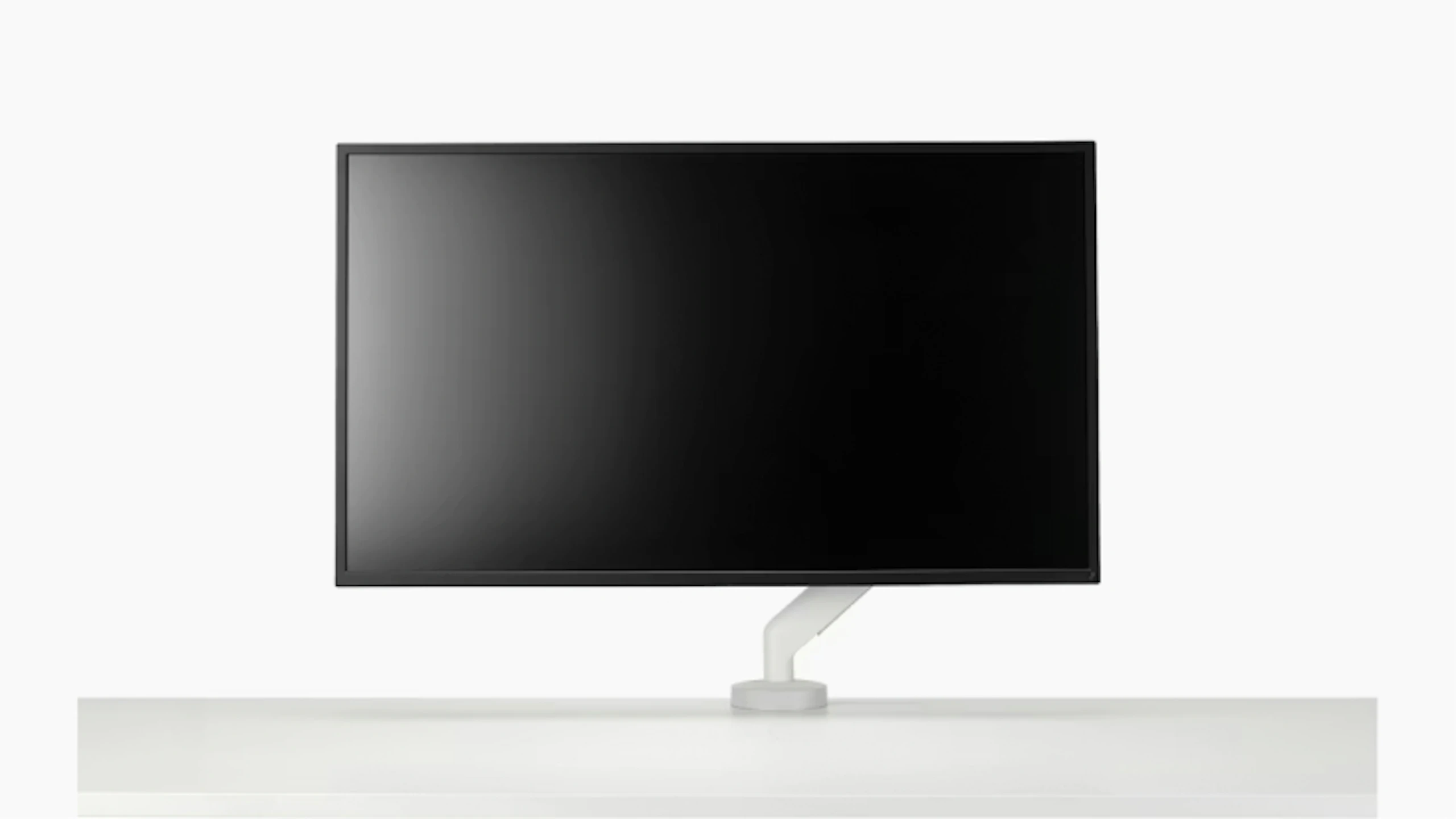 Black computer monitor mounted on a white Flo X Single Monitor Arm by Herman Miller.