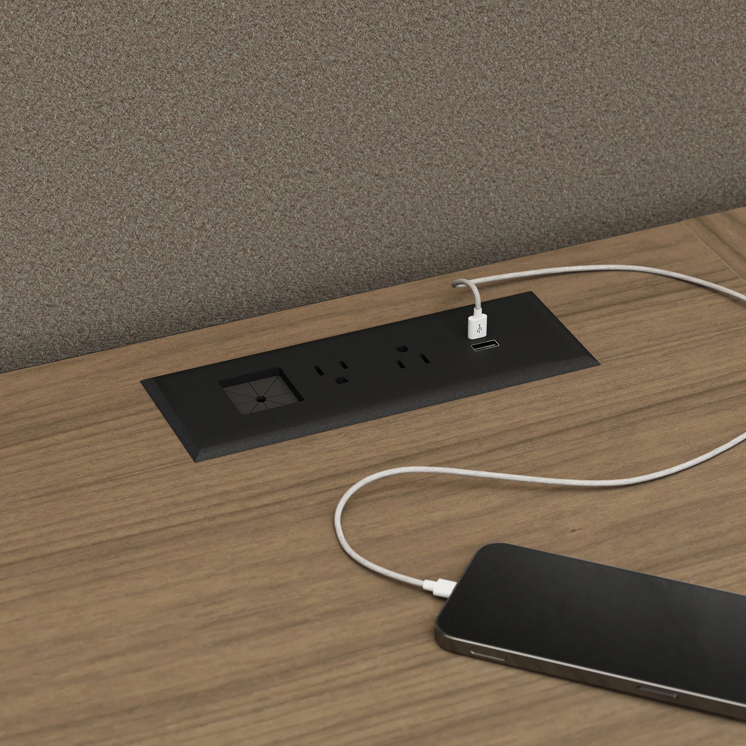 Detail shot of an in-surface power module charging a mobile phone in a Geiger One Private Office in Natural Flat Cut Walnut.