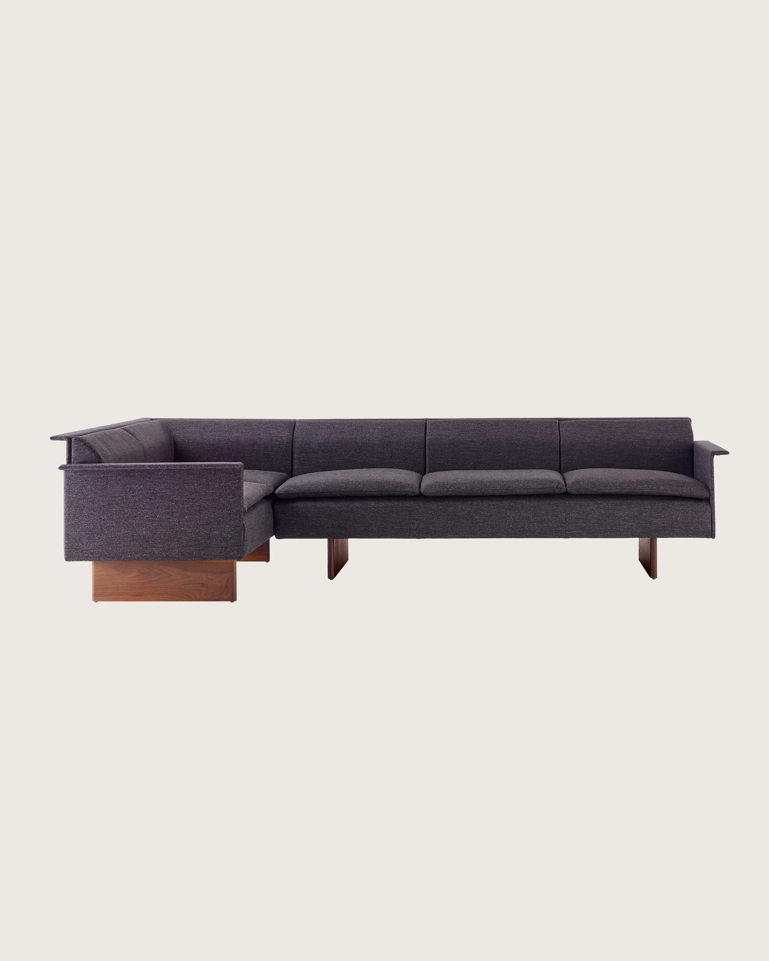 Mantle Sectional Sofa in Bellano Umber with a Walnut Base, viewed from the front.