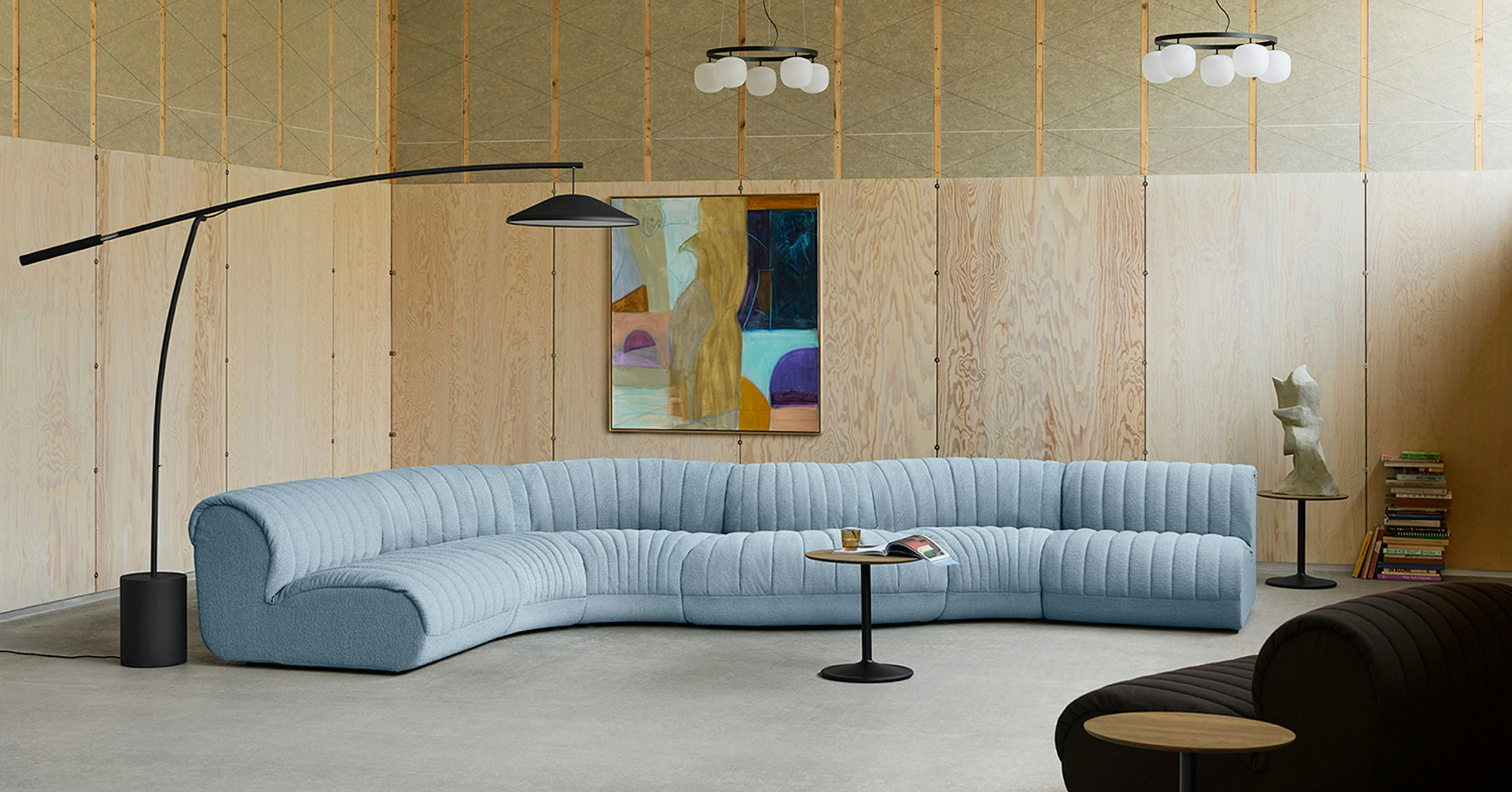 Light blue Coltre Sofa from Muuto in a large, well-decorated space.