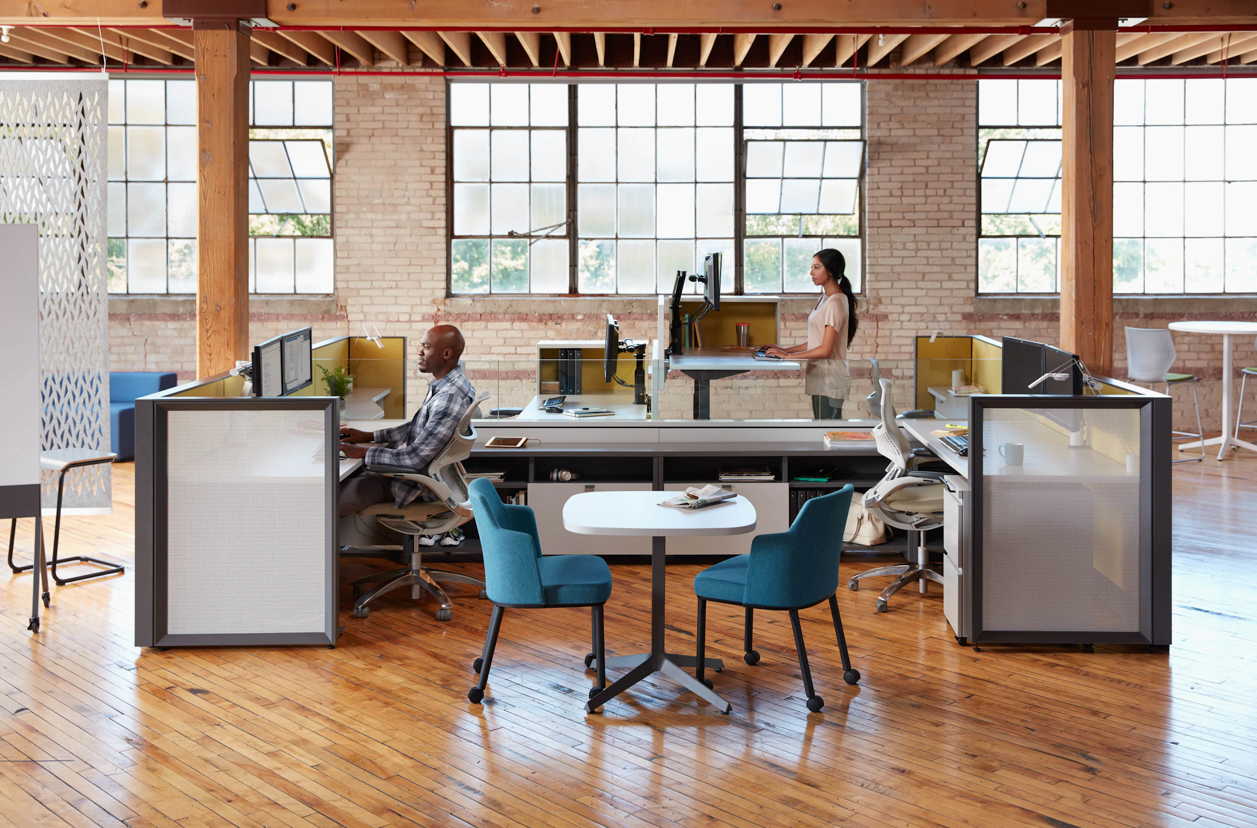 Open office setting showing two people at both standing and sitting height with Dividends Skyline.
