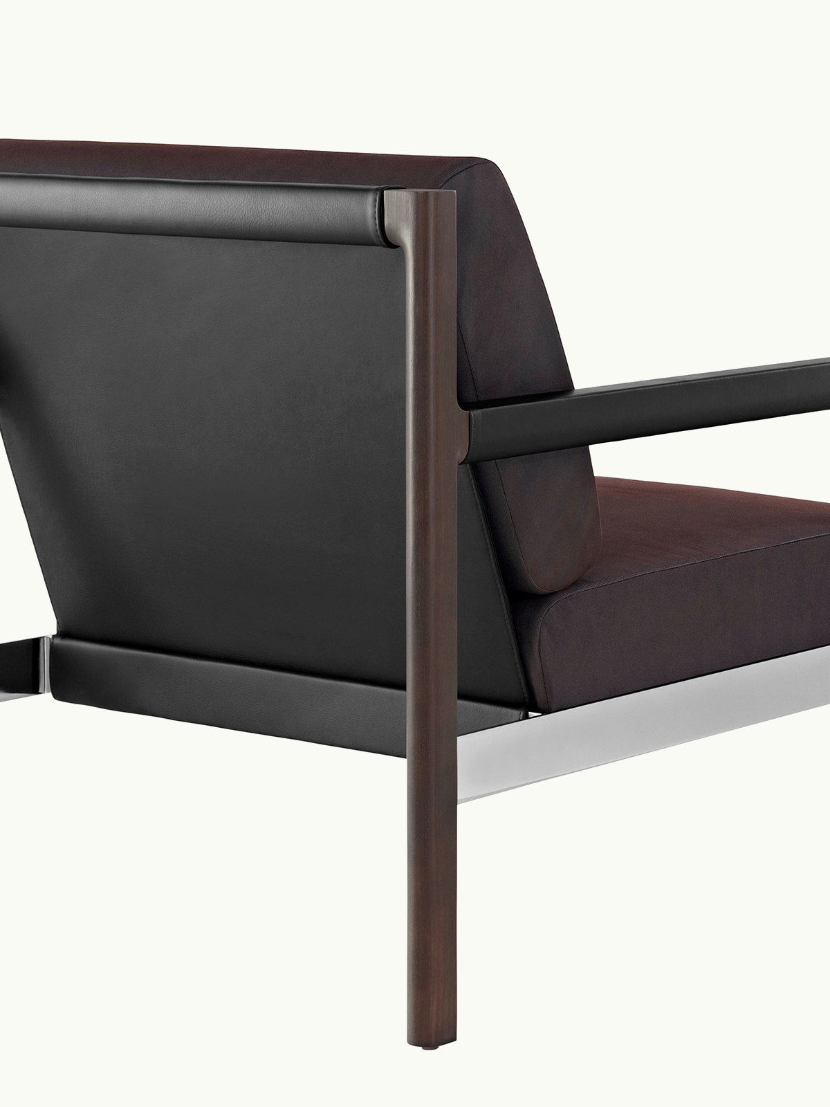 A Brabo Club Chair with dark brown upholstery; a black leather sling; metal accents; and an exposed wood frame; viewed from behind at an angle.
