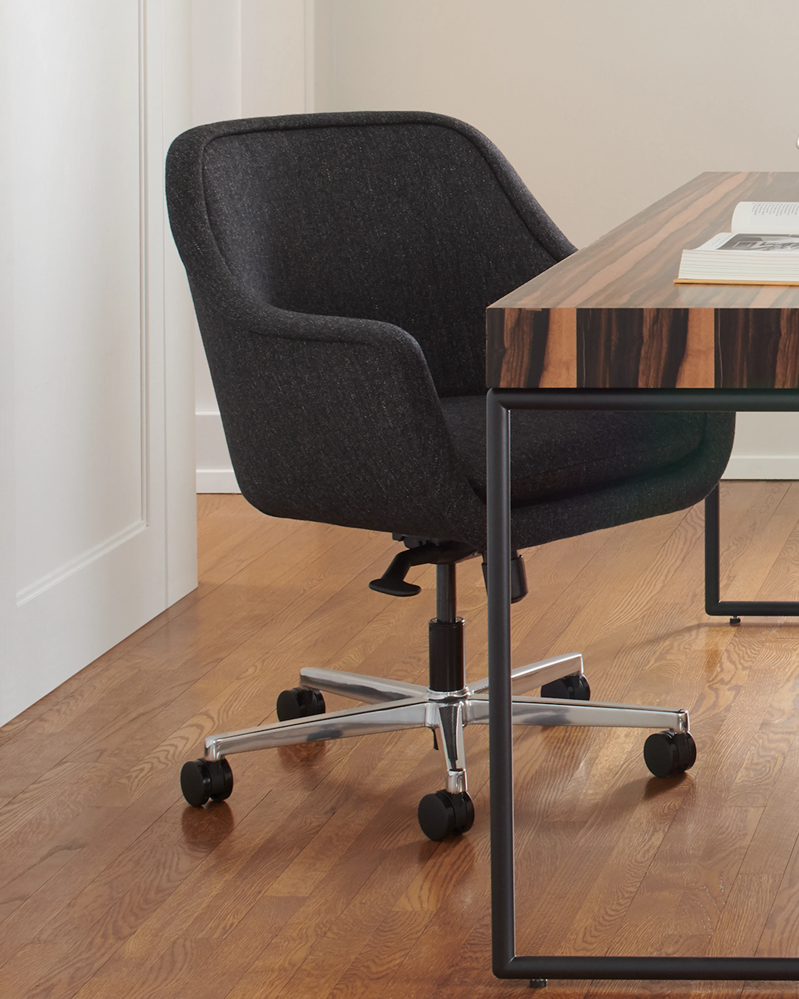 A private office featuring a Domino Desk, a Bumper Chair, and Rapport Settee.