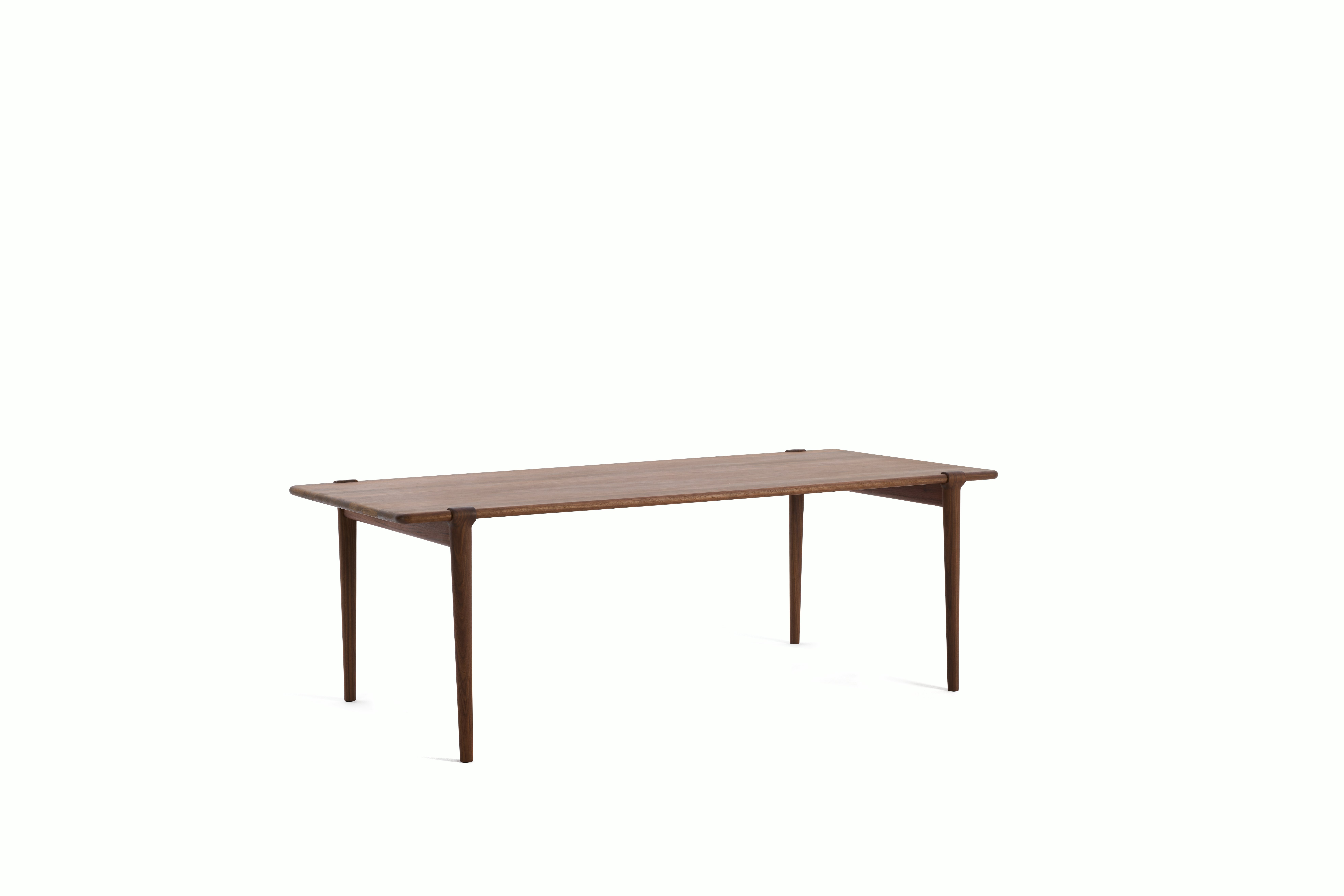 An Otto Dining Table in Walnut viewed from an angle.