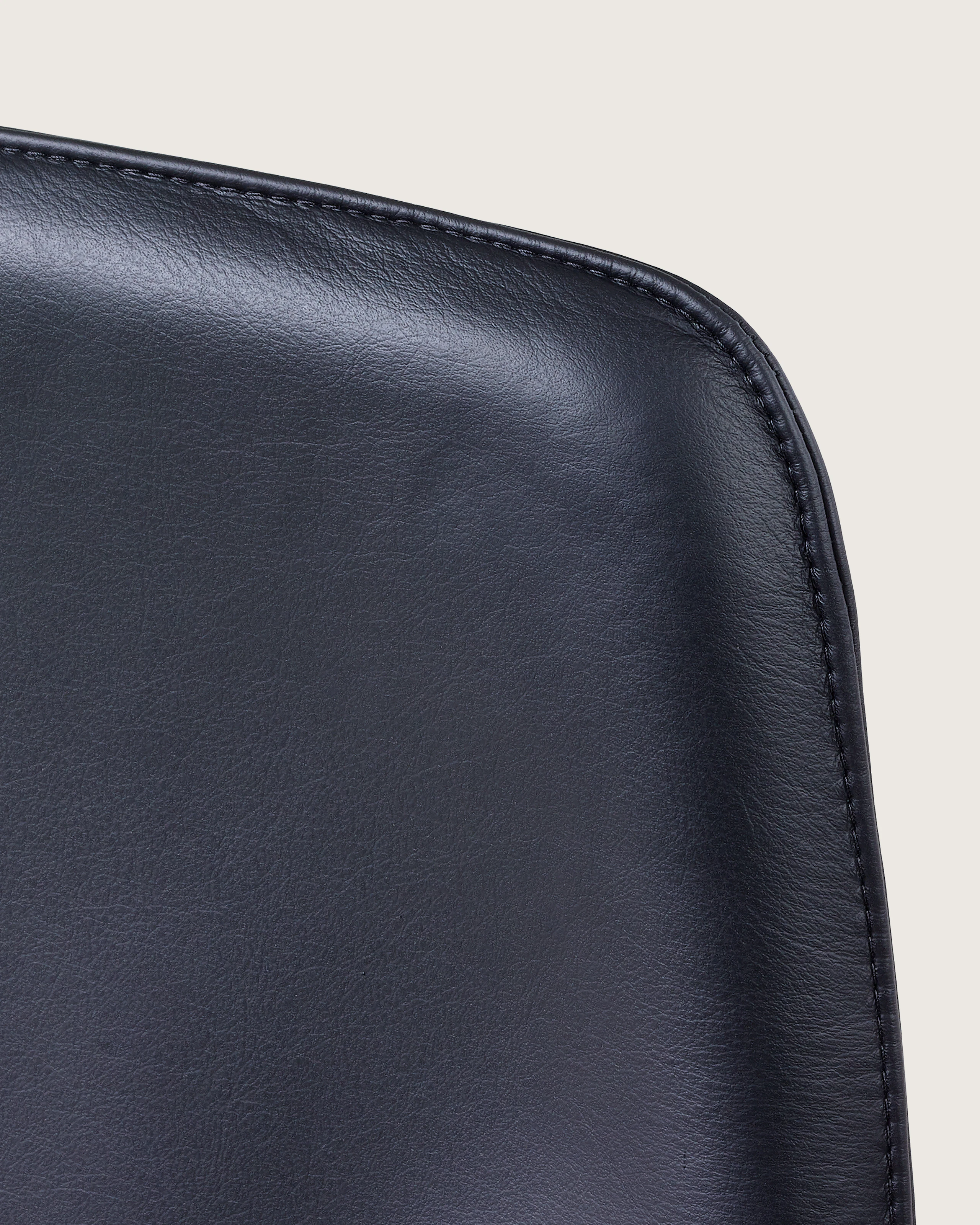 Close-up of an upper corner on the back of a Taper office chair, showing the lapped-edge stitch option.