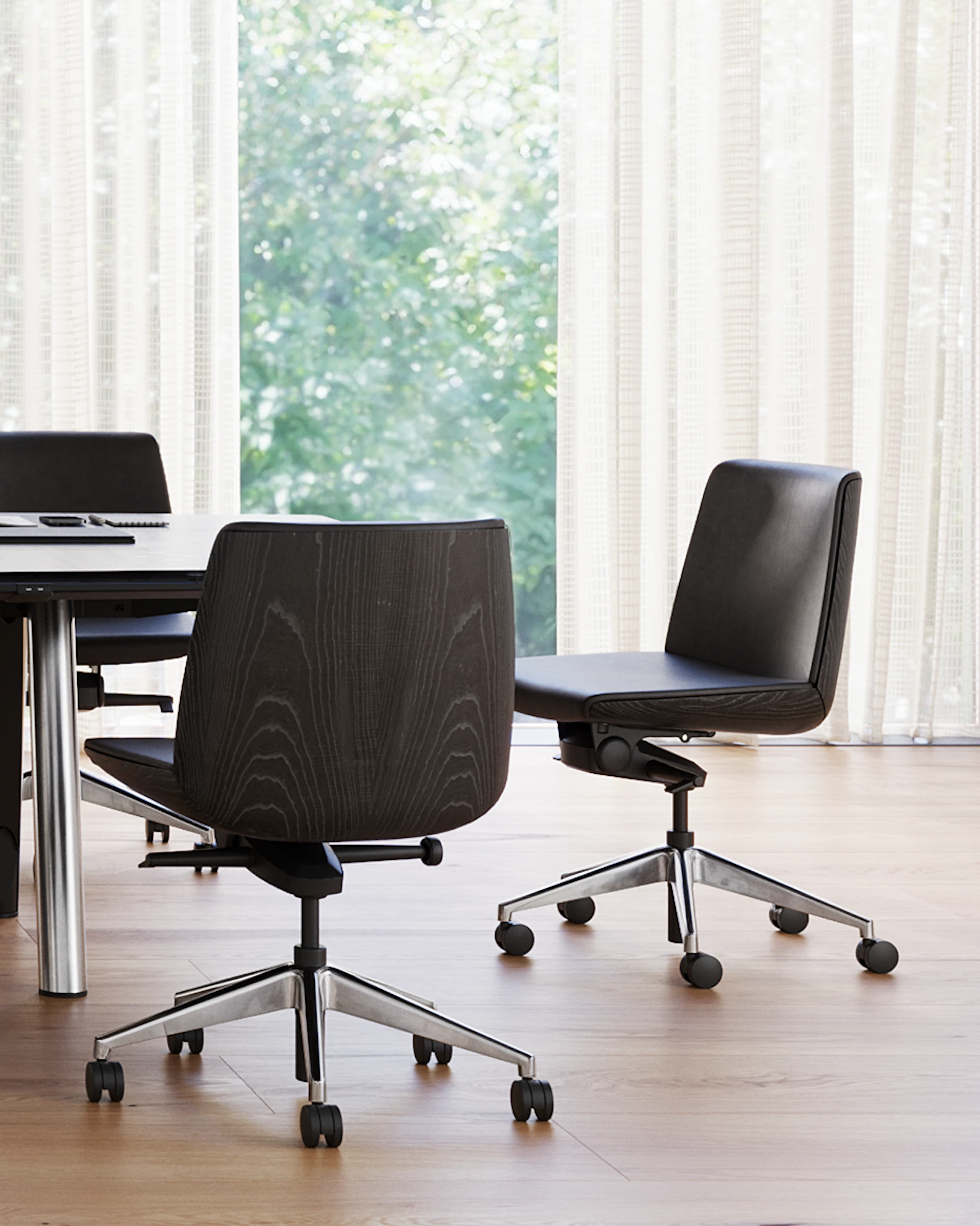 Ascent Conference Table and Credenza by EOOS, paired with Clamshell Chairs, shown with a dark grey etched back-painted glass top and chrome base on the table, viewed from the side in a conference room setting.