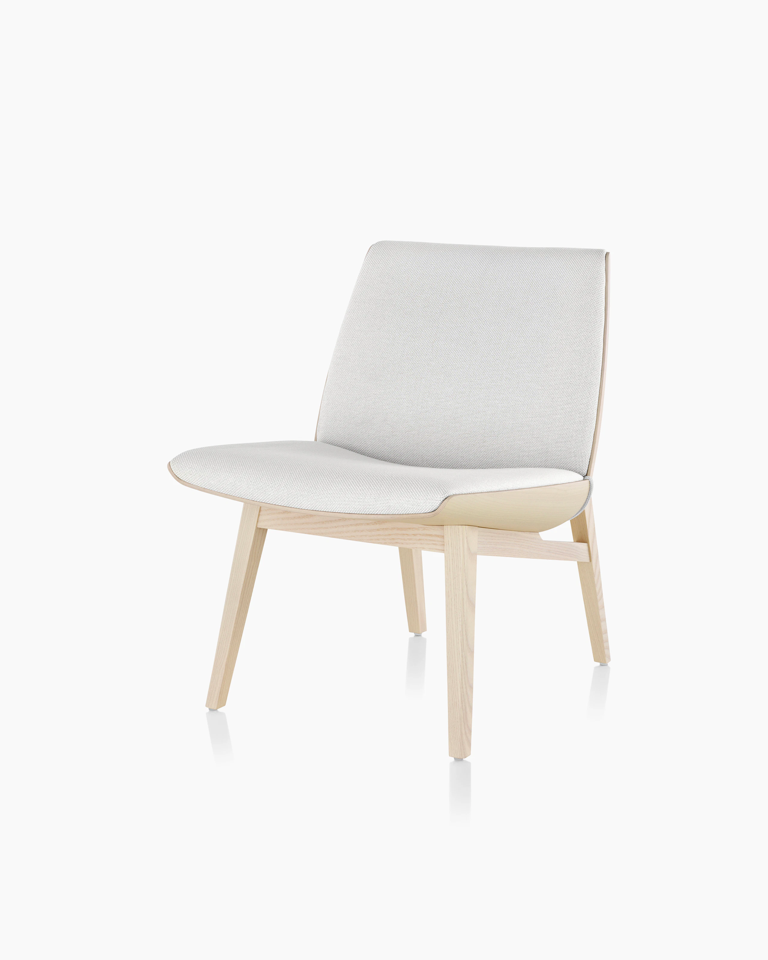 Angled view of a low-back Clamshell Lounge Chair with off-white fabric upholstery and light-ash legs.