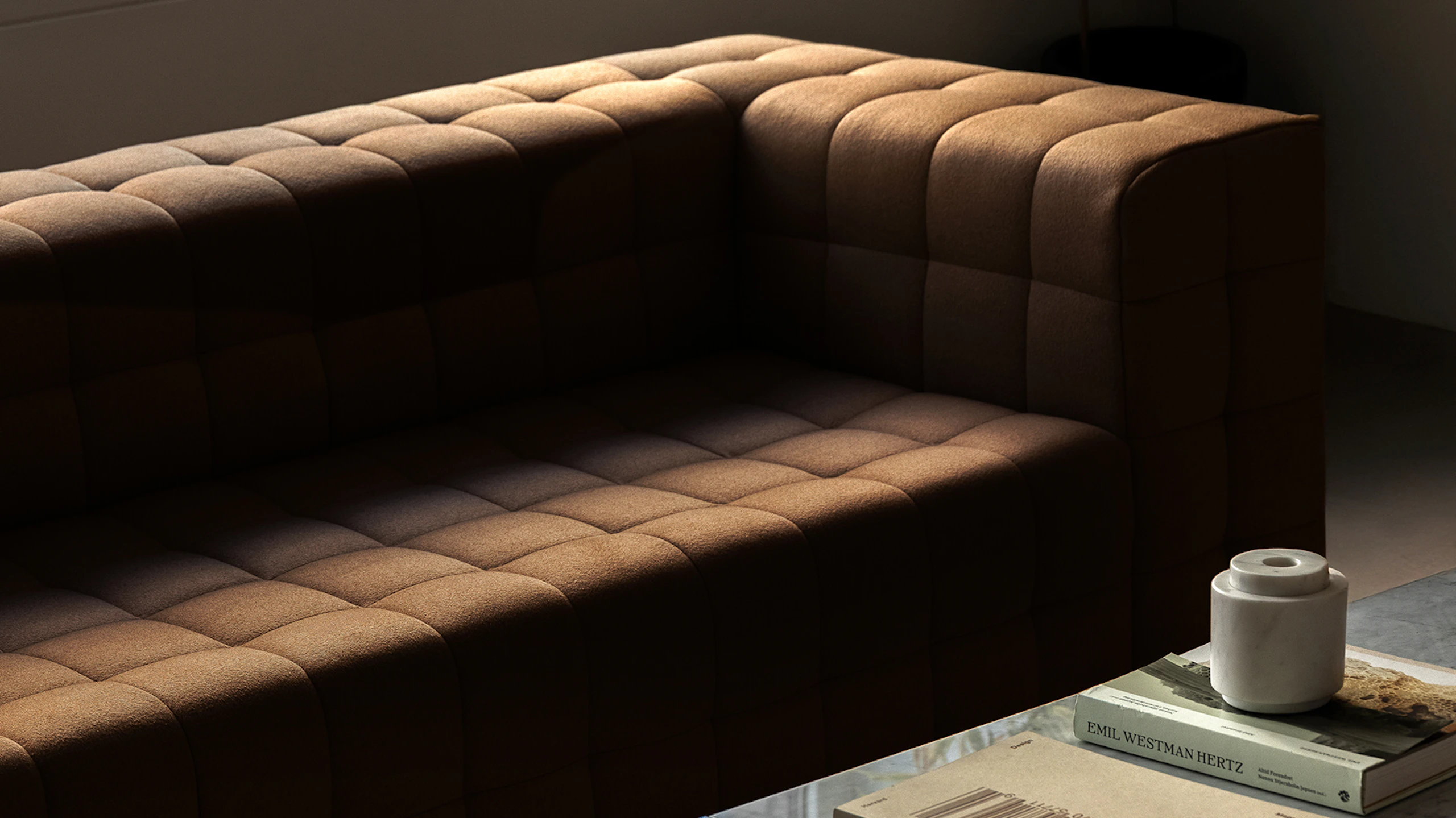 Rapport Sectional Sofa upholstered with Brushed Camel in Natural and an H Frame Coffee Table with a Carrara White marble top and chrome frame, viewed at an angle in a showroom setting.