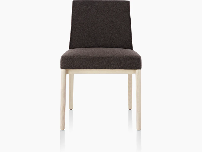 An armless Nessel side chair with black fabric upholstery and a wood frame with a light finish, viewed from the front.