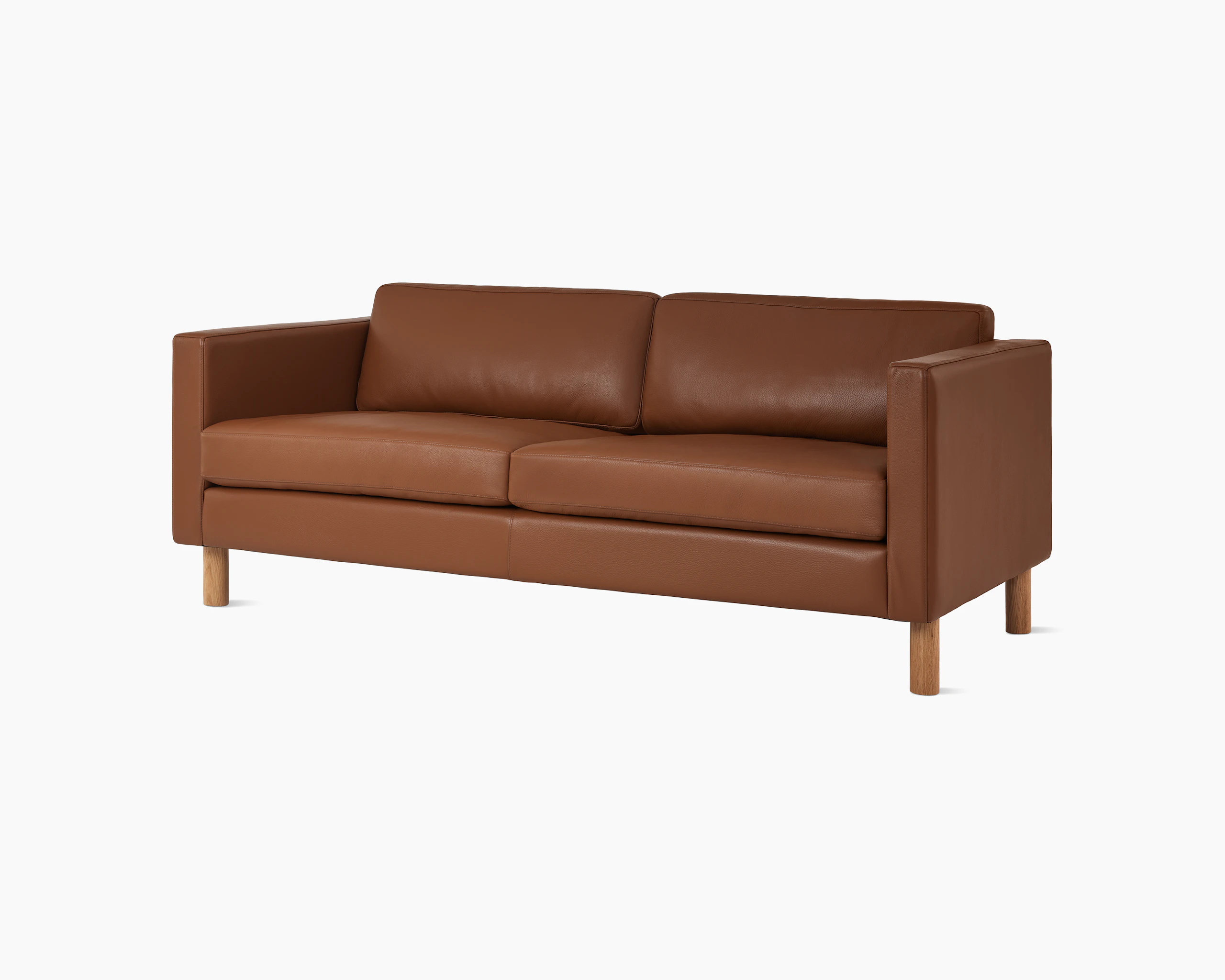 Lispenard sofa with brown leather upholstery and walnut legs, viewed from an angle.