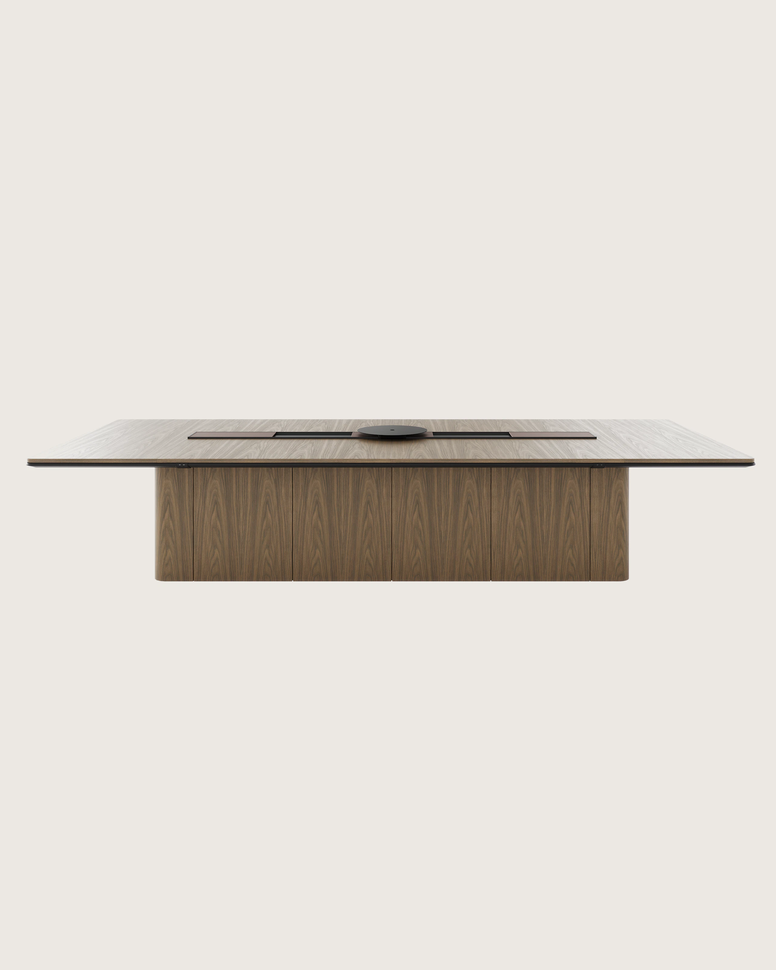 60"x144" Ascent Conference Table designed by EOOS in Natural Flat Cut Walnut with a plinth base, central power trough, an AV platform, and accessory trays, viewed from the front.