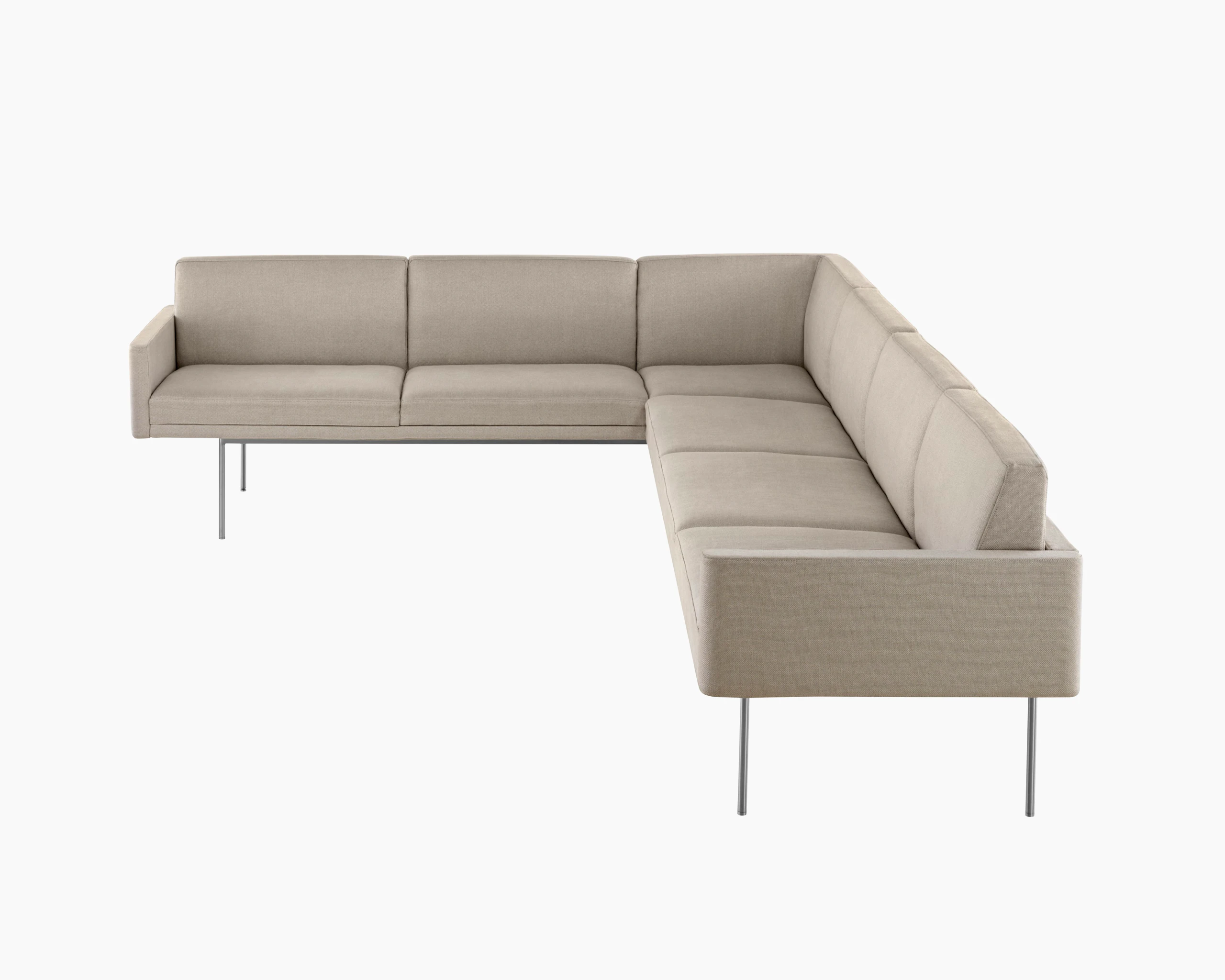 Partial view of a non-quilted Tuxedo Component corner unit upholstered in beige fabric.
