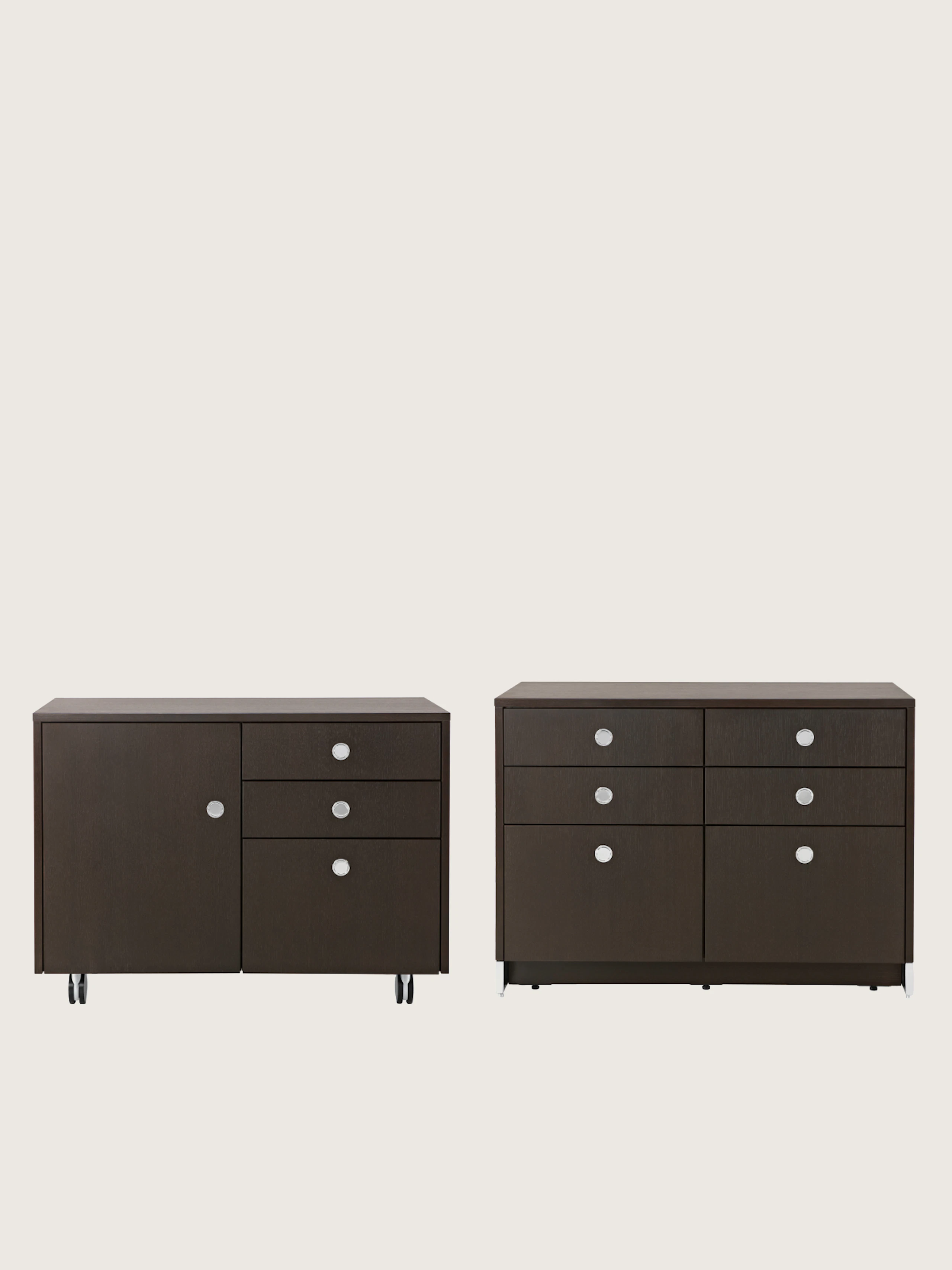 Two Sled Base Storage units designed by Ward Bennett, one pedestal unit with casters front-facing, one credenza with casters viewed at an angle, on a white sweep.
