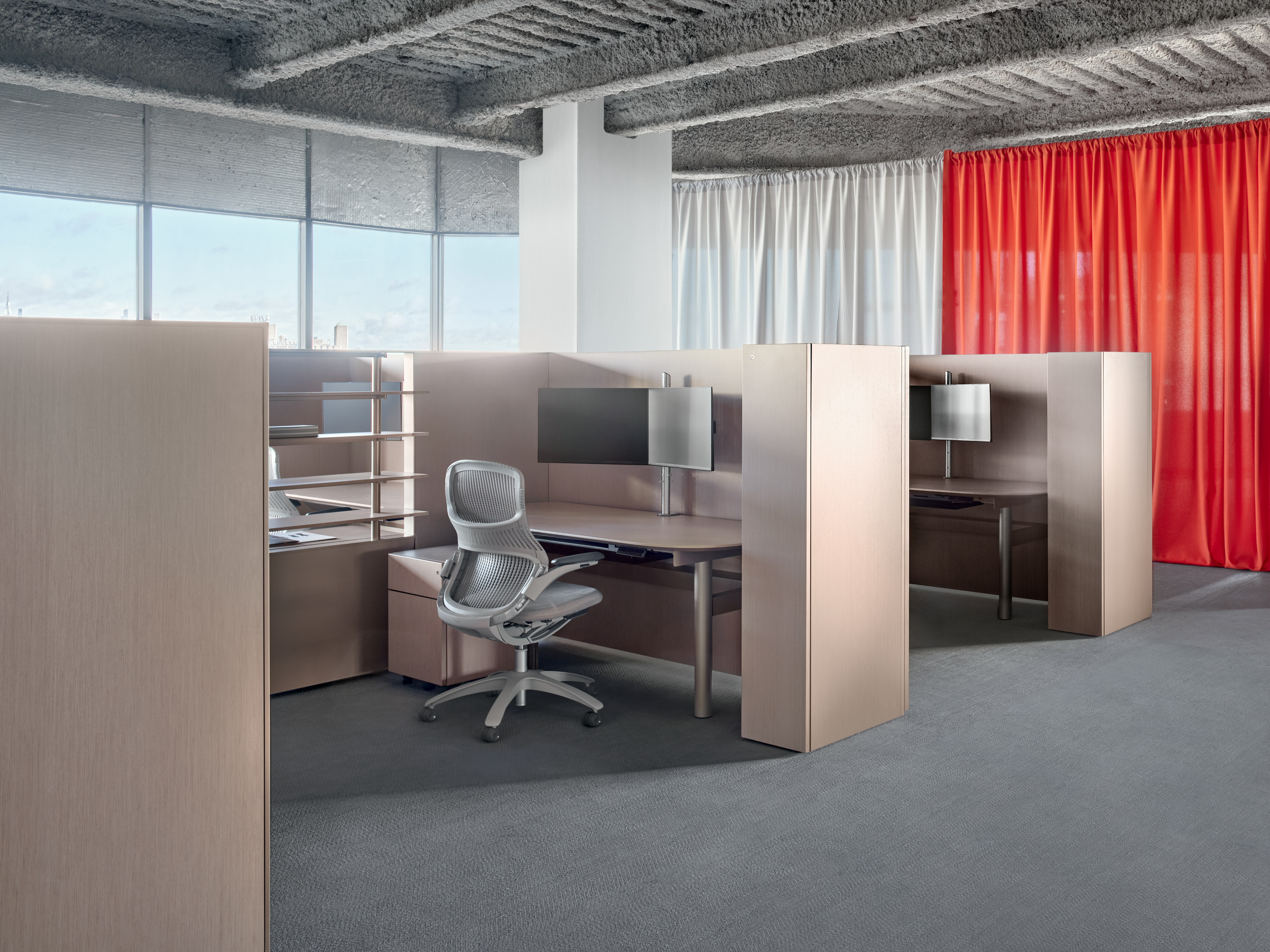 A group of panel system workstations are in an open floorpan office. In front of the desks are work chairs along with personal storage.