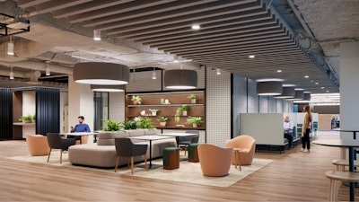 Several persons using a communal seating area with a variety of seating configurations including DWR Lina Swivel Chairs, private booths, and large grey bench seating