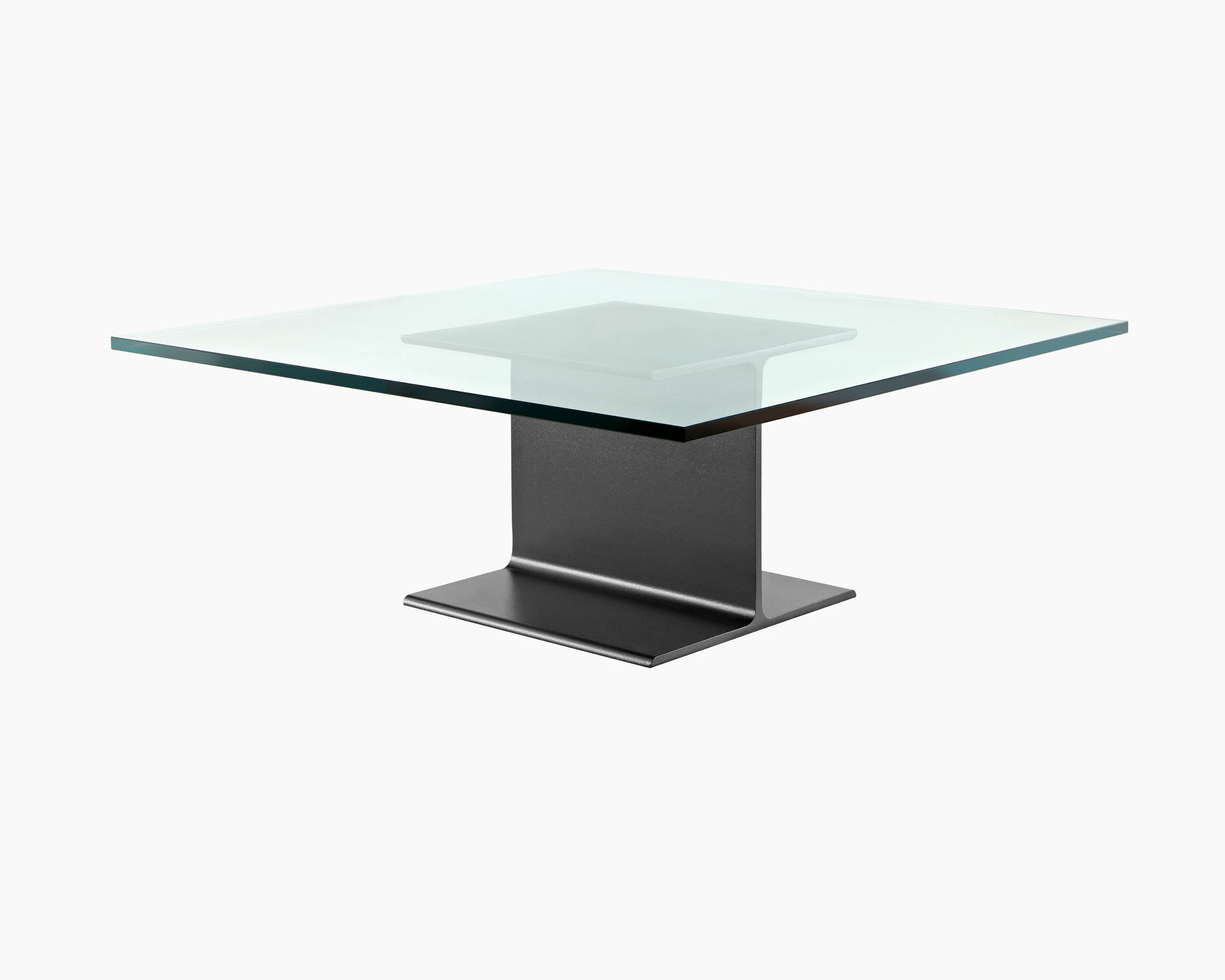 Partial angled view of a square I Beam coffee table with a glass top and black cast-aluminum pedestal.