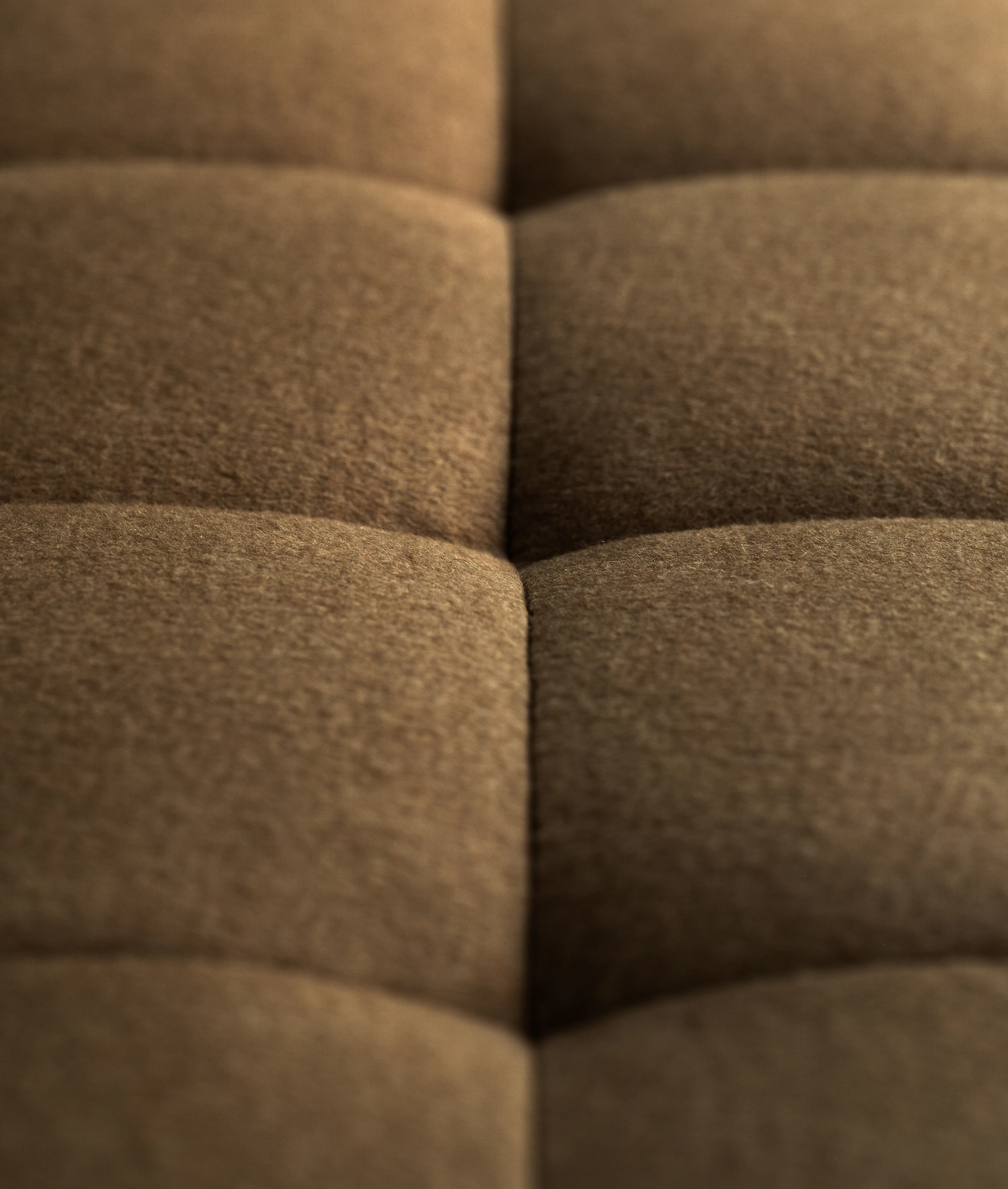 Detail view of the tufted squares on the seat of a Rapport Sectional Sofa upholstered with Brushed Camel in Natural.