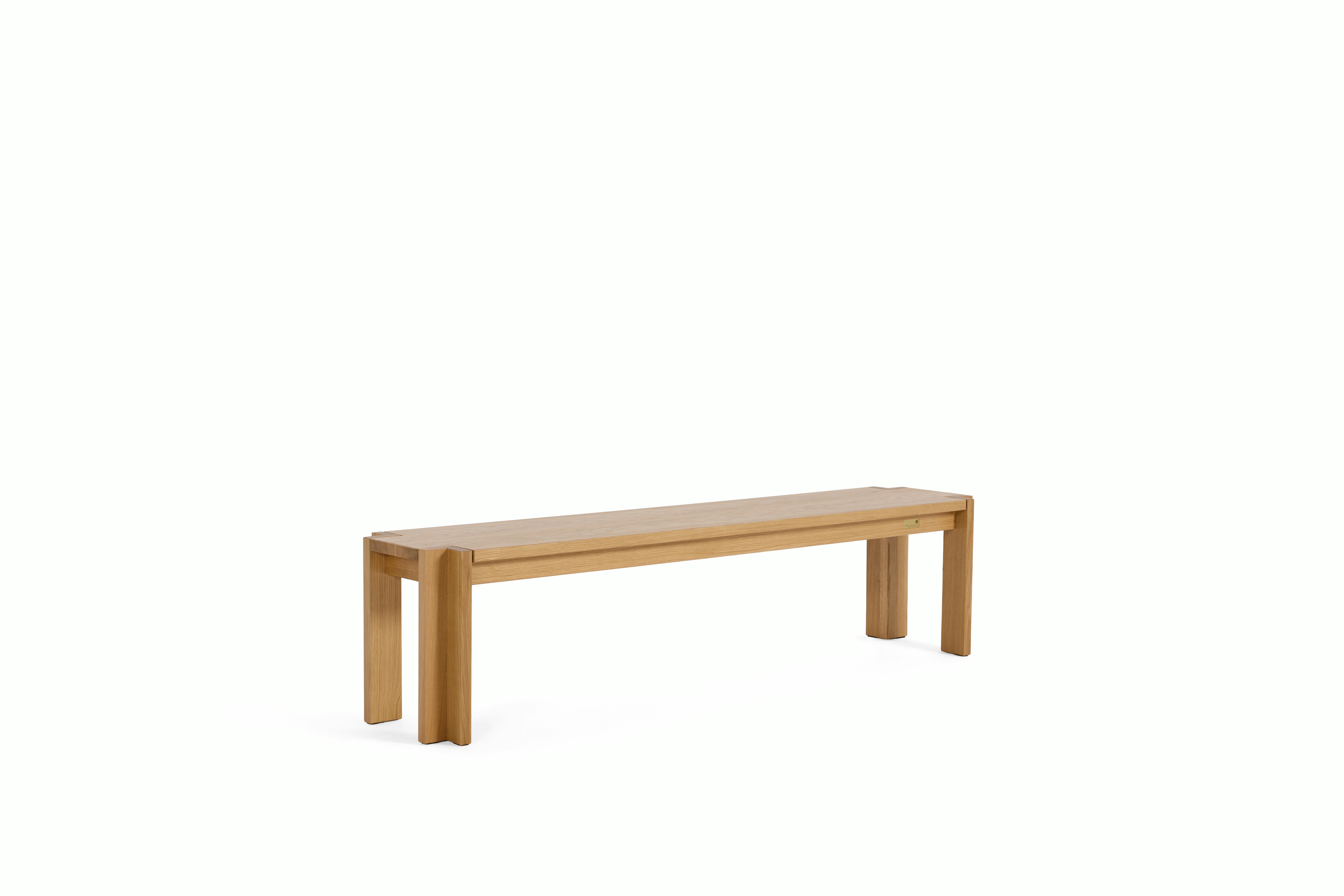 A Utzon Dining Bench in Oak viewed from an angle.