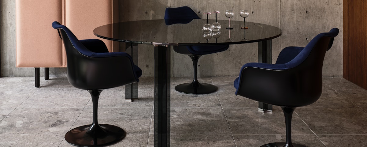Three Saarinen Tulip Armchairs surrounding an X-T Dining Table in a dining room setting