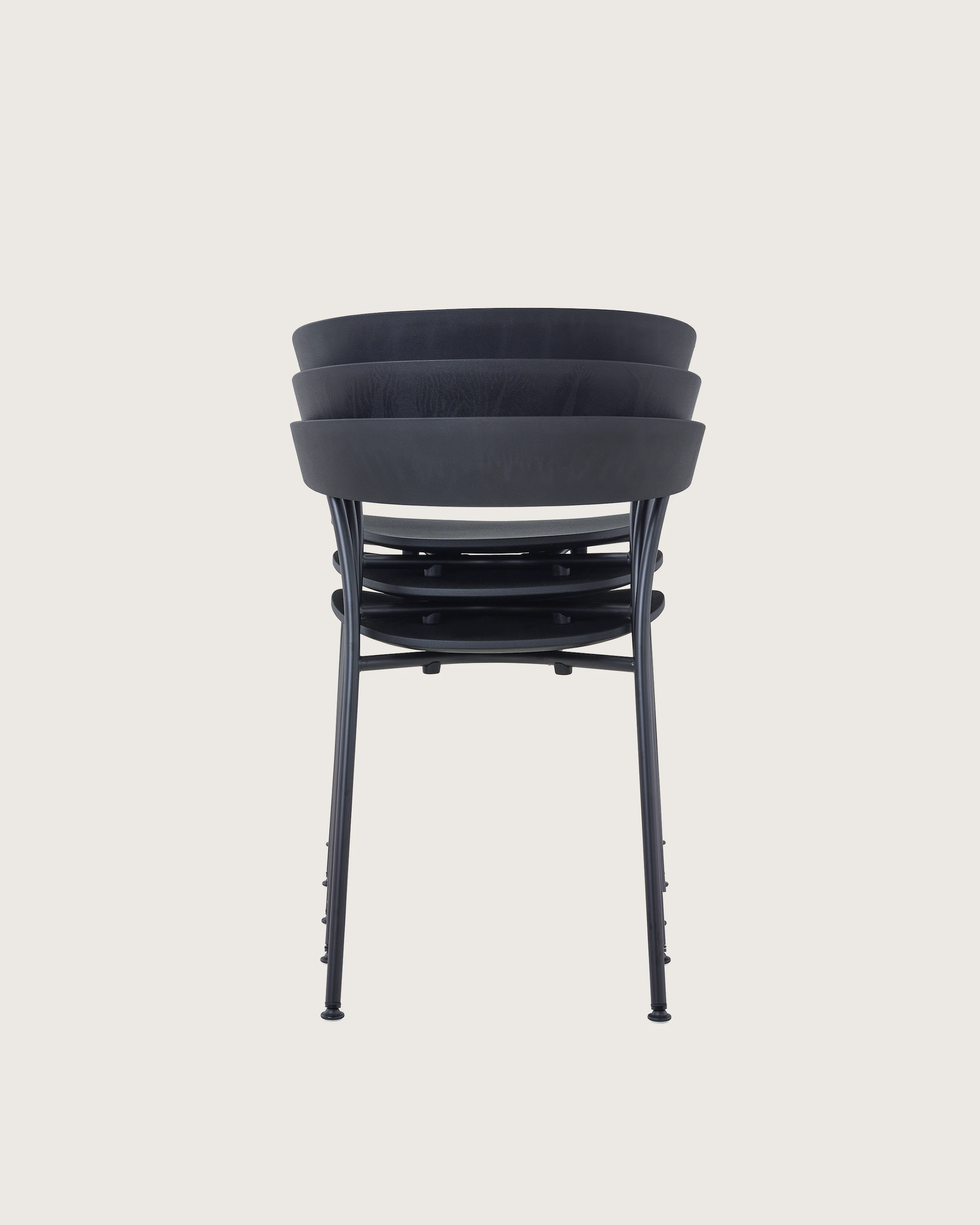 A stack of three black Leeway Chairs, viewed from the back.