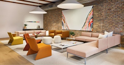 A variety of colorful sofas and assorted seating from NaughtOne decorate this communal seating area at MillerKnoll Design Days