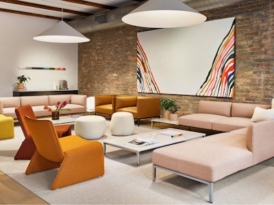 A variety of colorful sofas and assorted seating from NaughtOne decorate this communal seating area at MillerKnoll Design Days