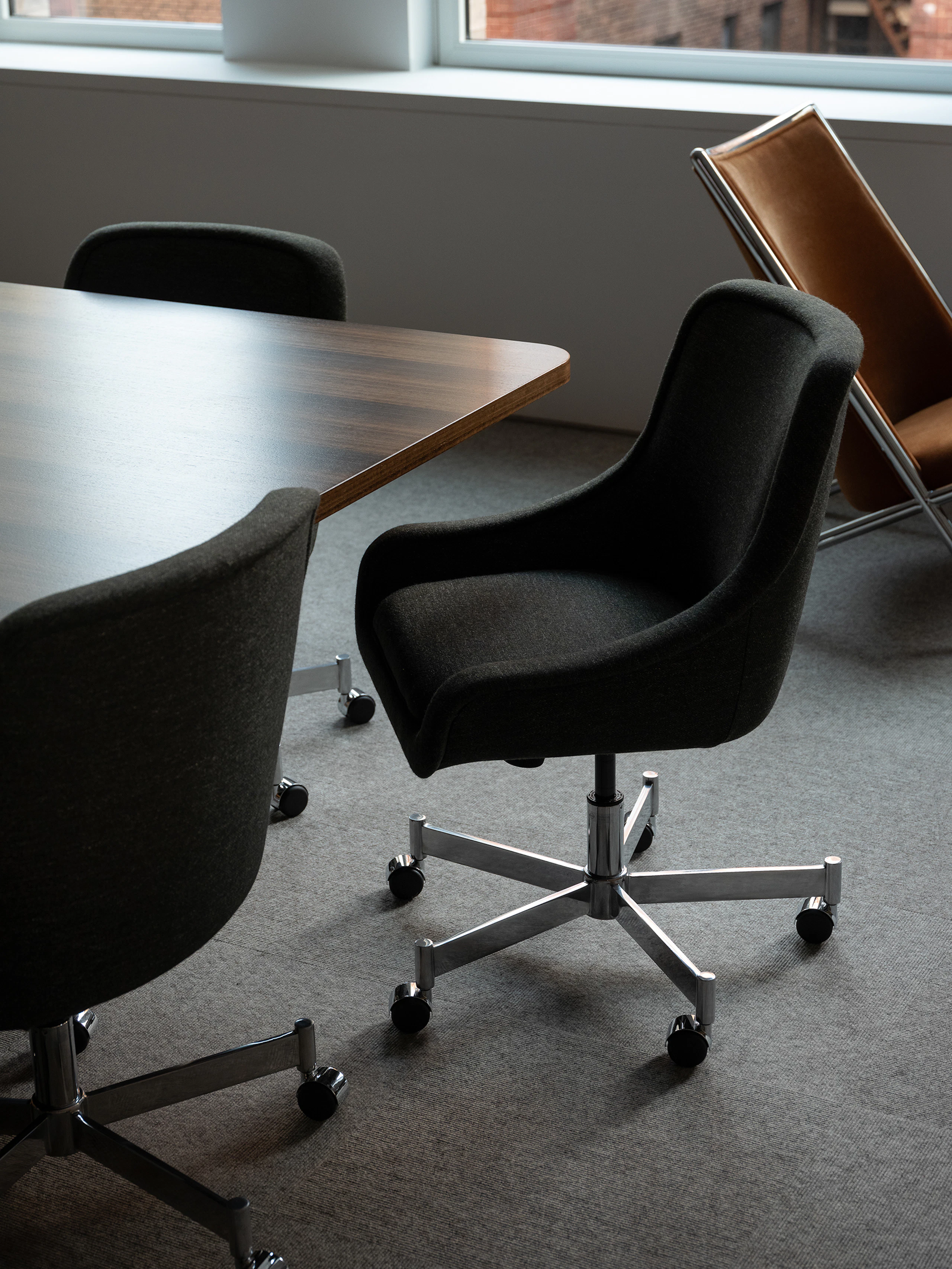 Bumper Conference Chairs with low arms upholstered with Bellano Black Green around a JD Conference Table in Fumed Quarter Cut Eucalyptus.