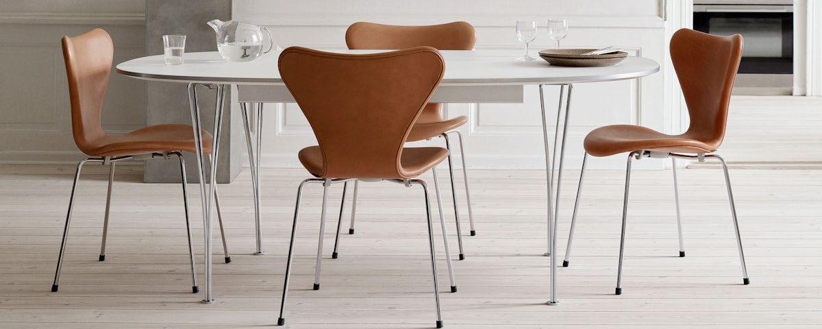 Superellipse Dining Table surrounded by Series 7 Upholstered Dining Chairs in a dining room setting
