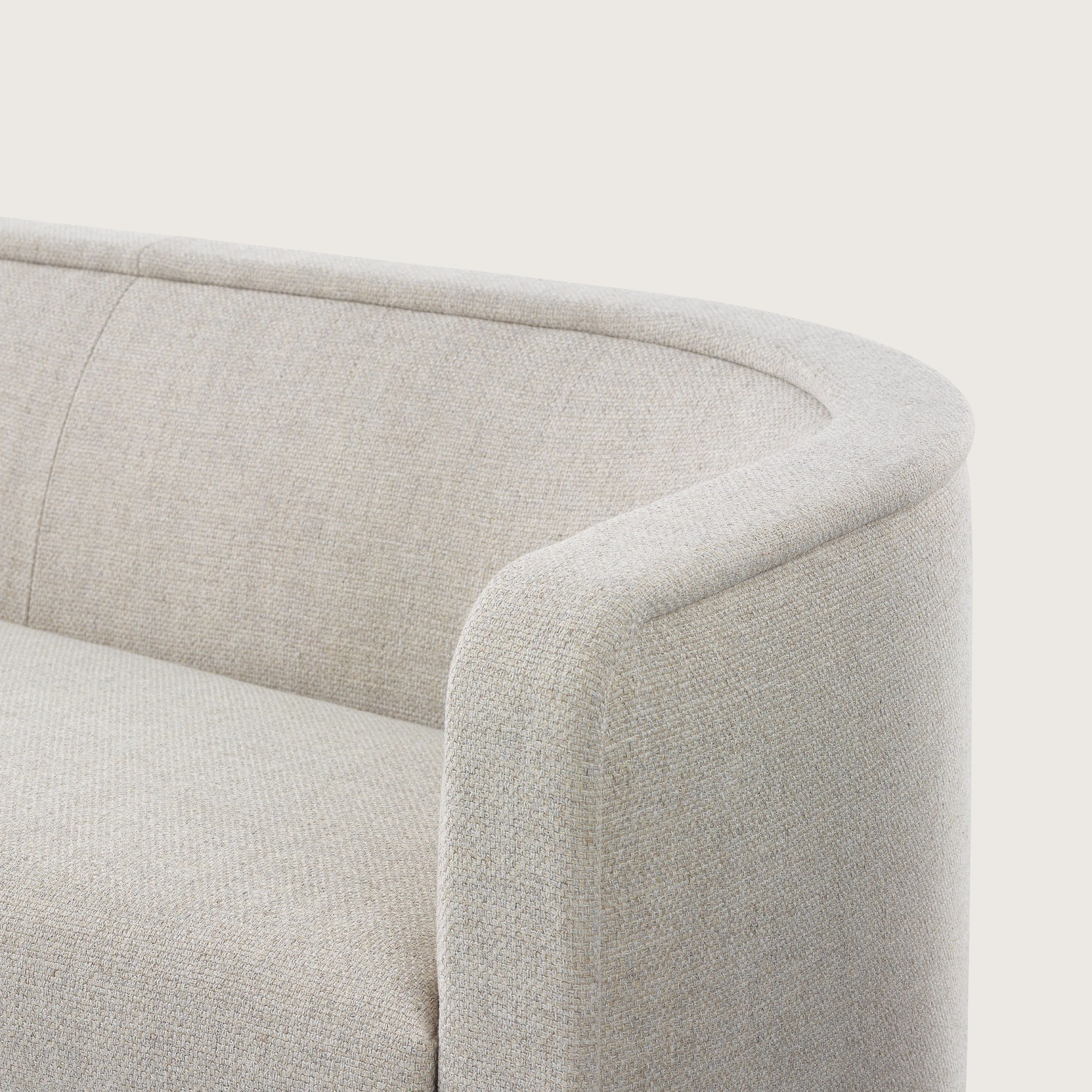 Close up of a U-Series Settee upholstered in a light neutral fabric.