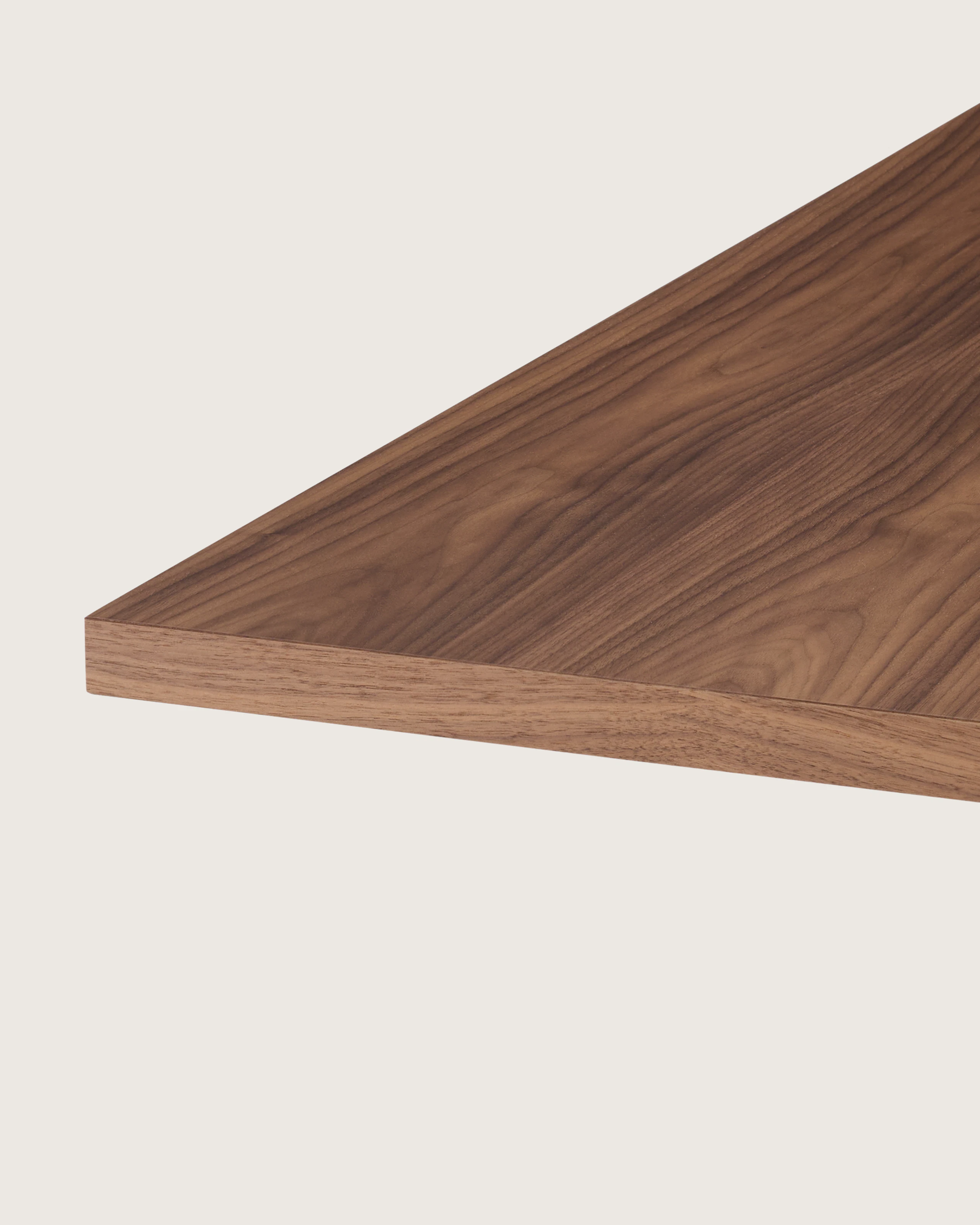 MP Table designed by Amir Paknya for Geiger in Natural Flat Cut Walnut shown on a white sweep, angled detail view of table edge.