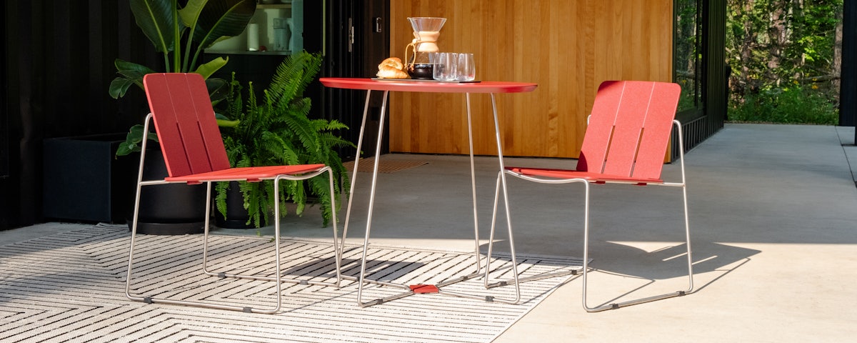 Two Keene Side Chairs and a Keene Dining Table with coffee and pastries in a patio setting
