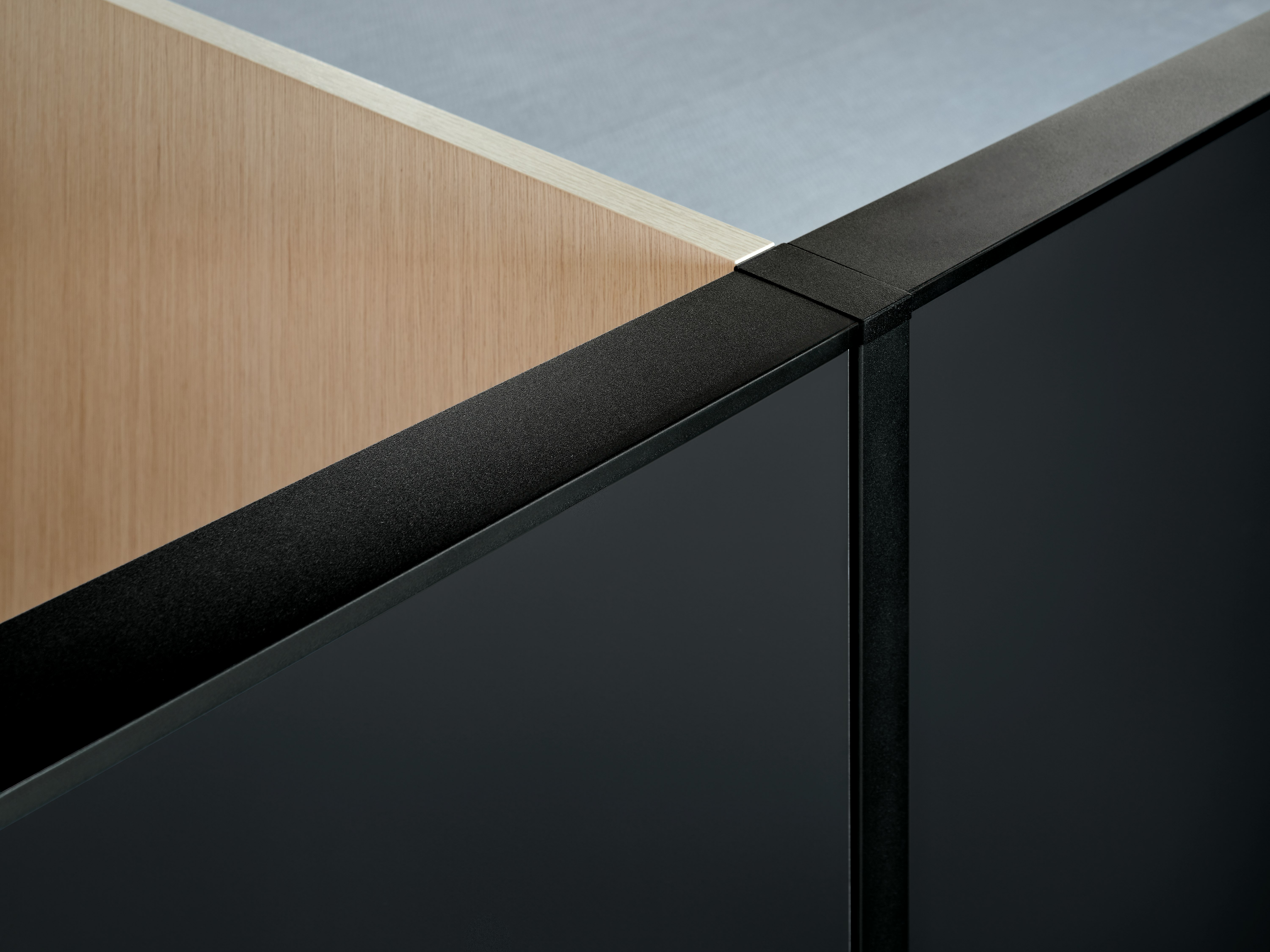 A veneer screen joins a gallery panel and aluminum trim at a 90 degree angle.