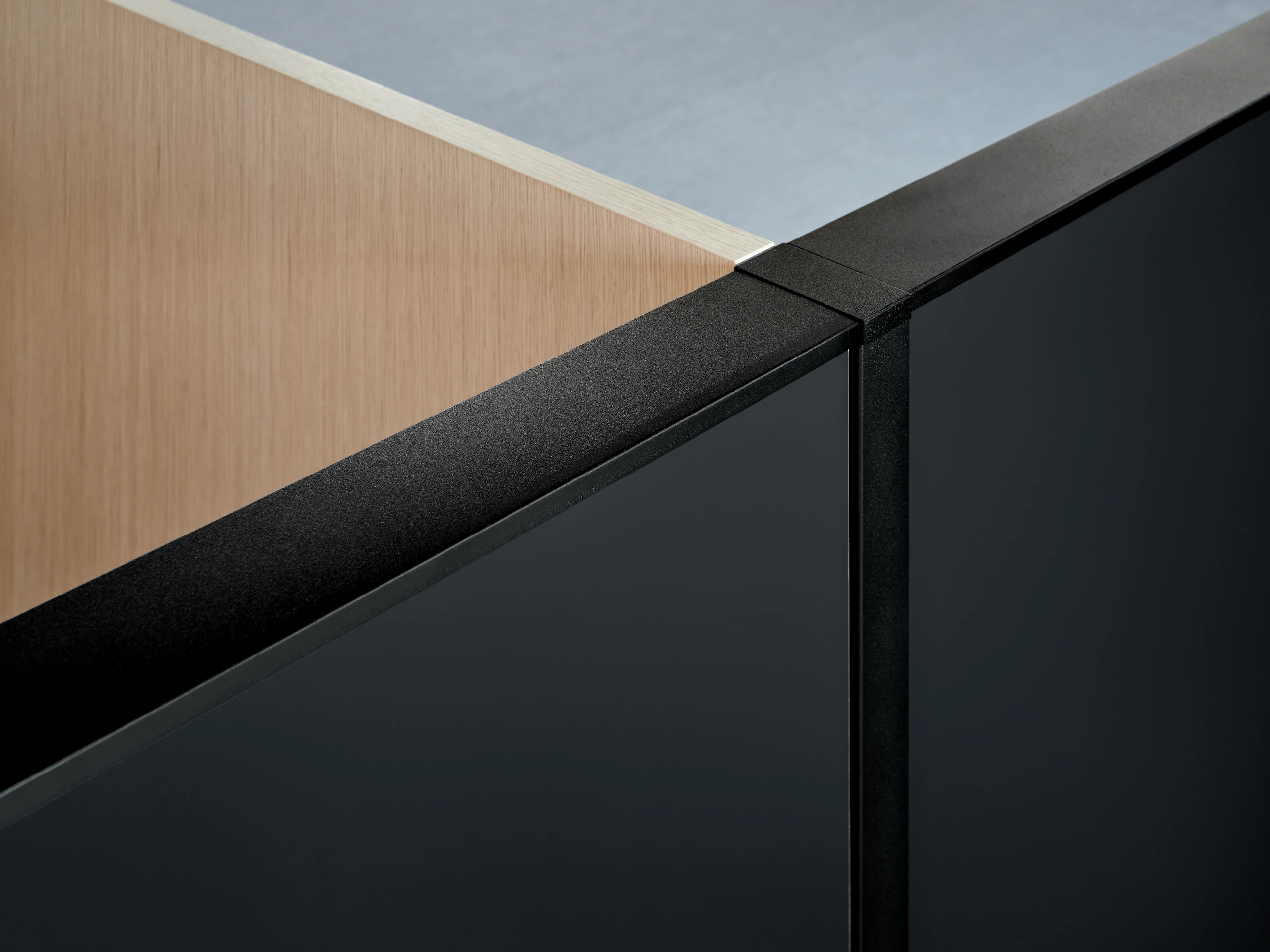 A veneer screen joins a gallery panel and aluminum trim at a 90 degree angle.